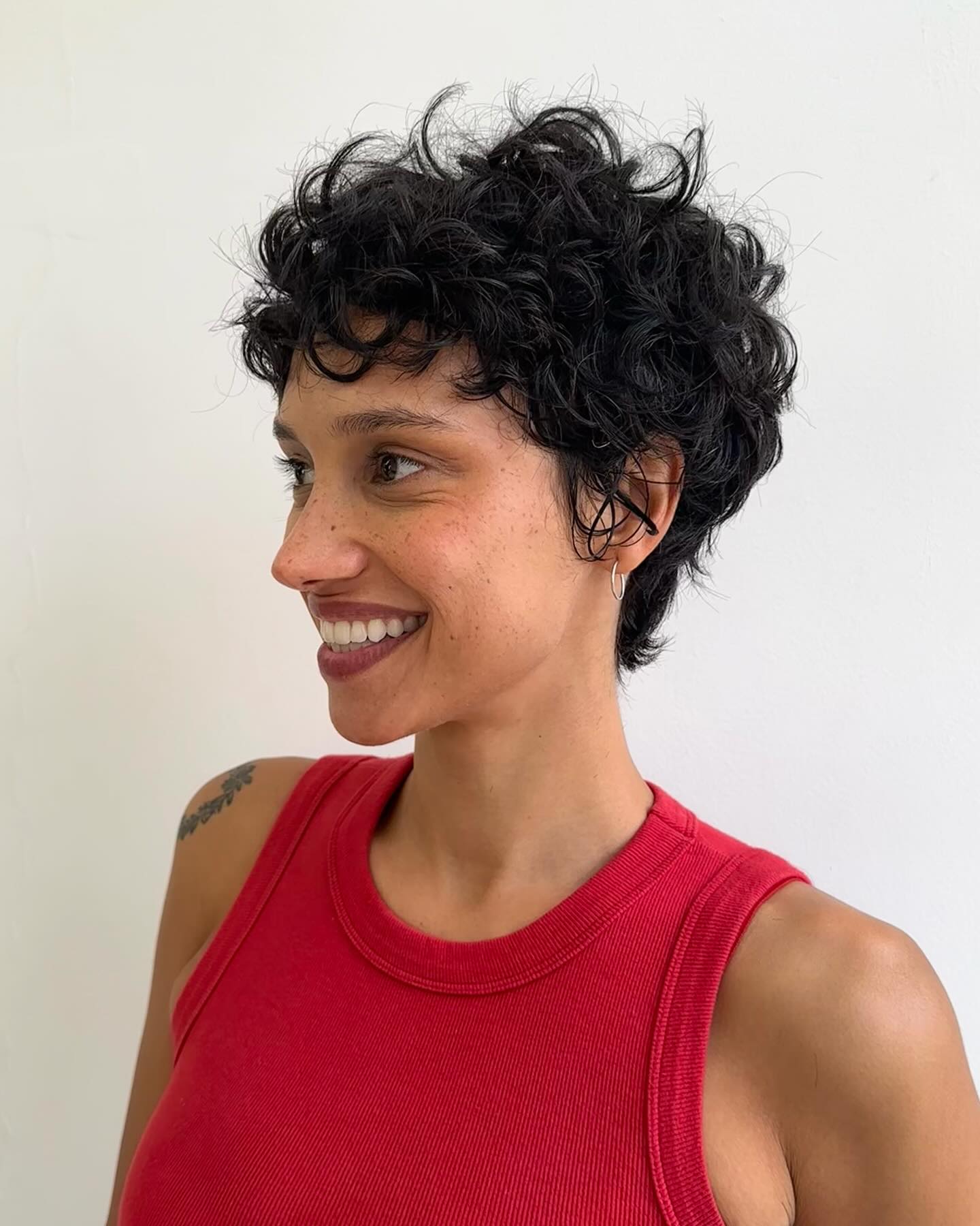 Short Curly Pixie with Soft Nape Taper and Defined Curl Clumps