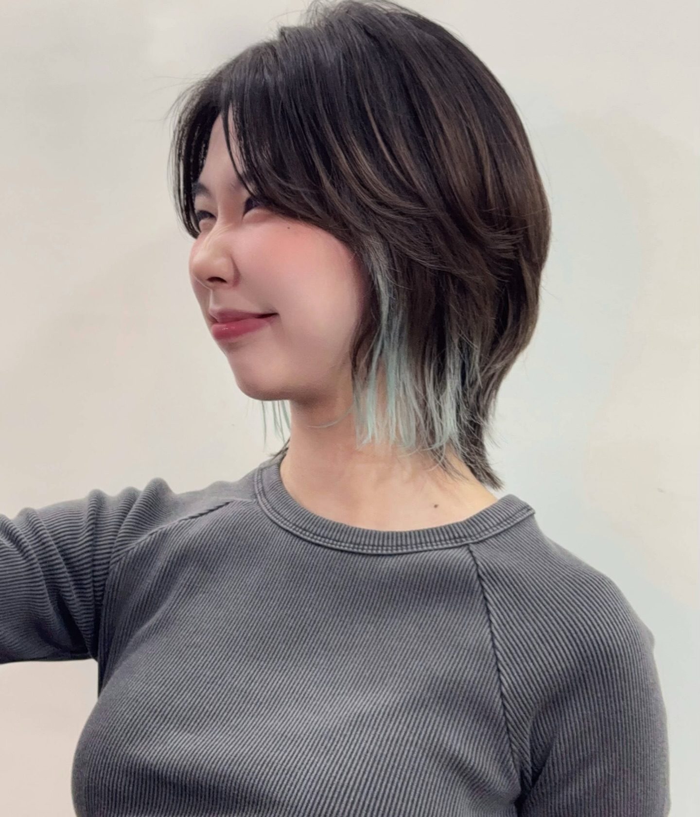 Cropped Wolf-Inspired Mullet with Brushed Curtain Bangs and Teal Underlights