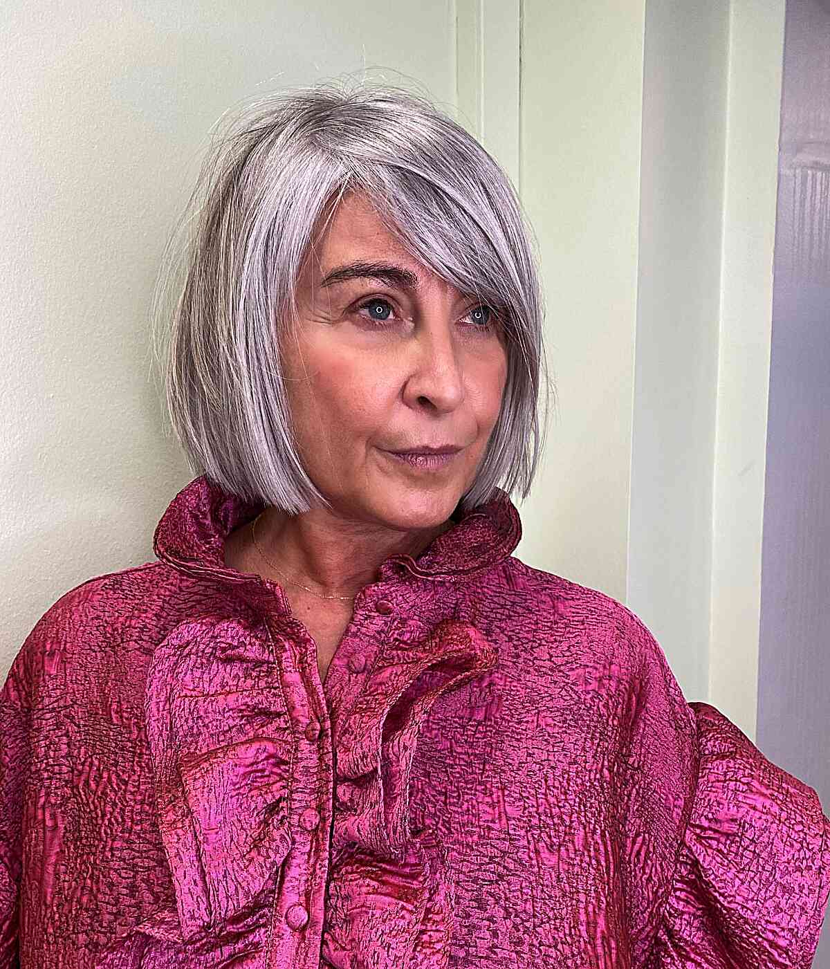 Grey Chin-Length Bob with Side-Swept Bangs on a Woman in Her 50s