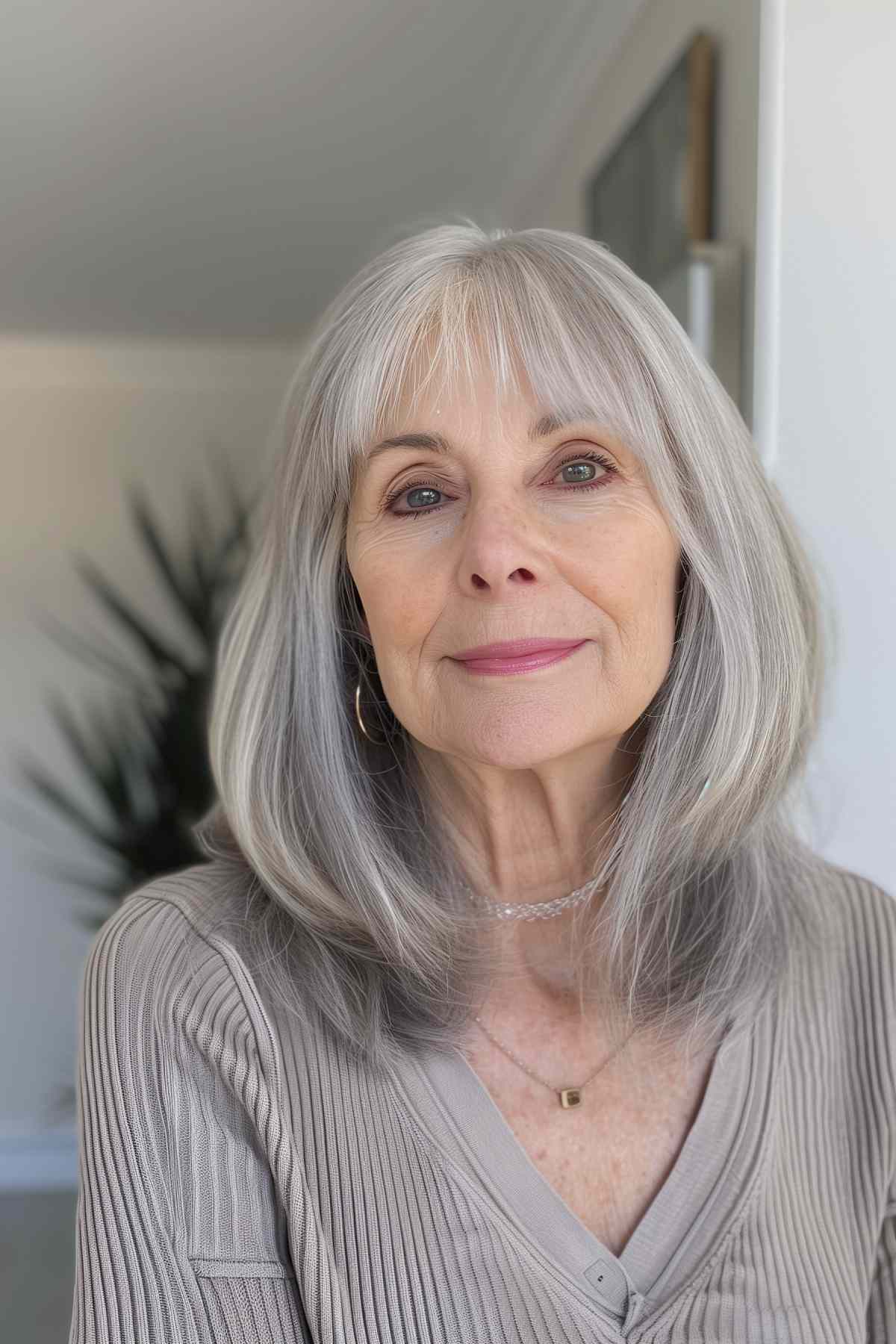 Older woman with medium grey hair and wispy bangs