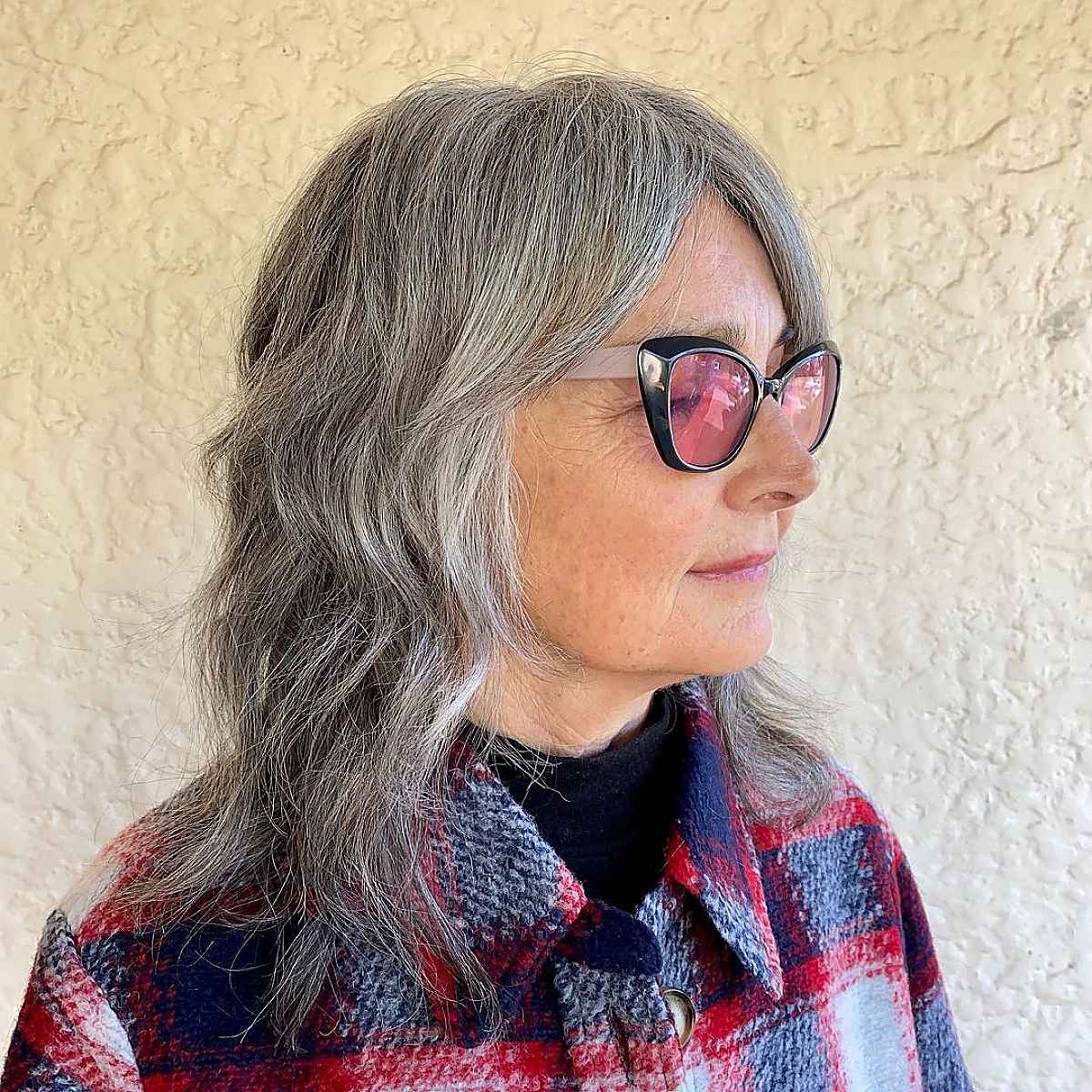 Grey shaggy mid-length haircuts are very trendy for women of all ages. If you're a woman over sixty and wanting this low-maintenance hairstyle, ask your stylist for a shaggy razor haircut. 
