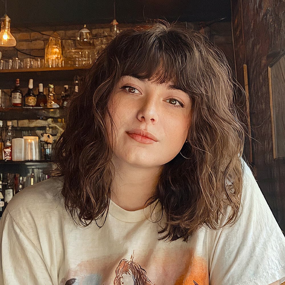 Tousled shoulder-length haircut with grunge-inspired layers and choppy bangs