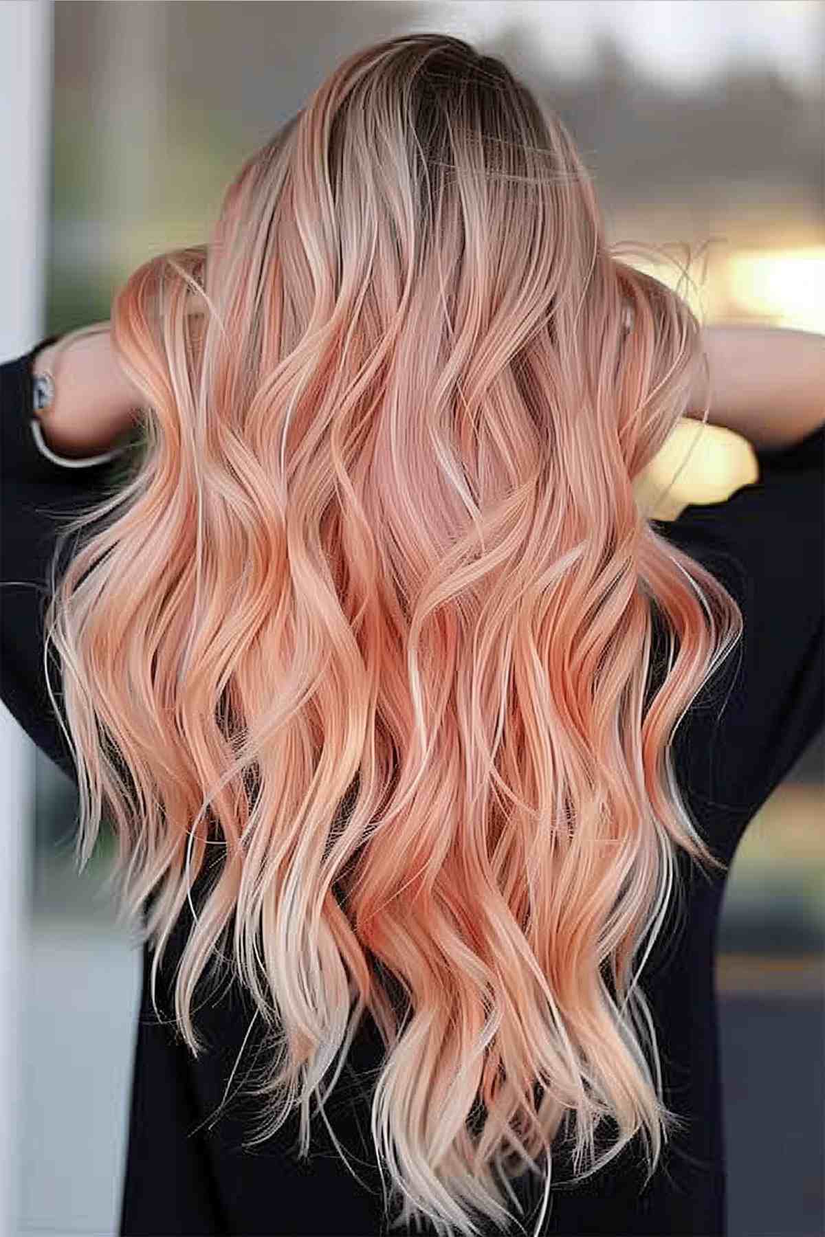 Medium-length wavy hair with a gradient of natural blonde to soft peach balayage, demonstrating volume and a playful summer look.