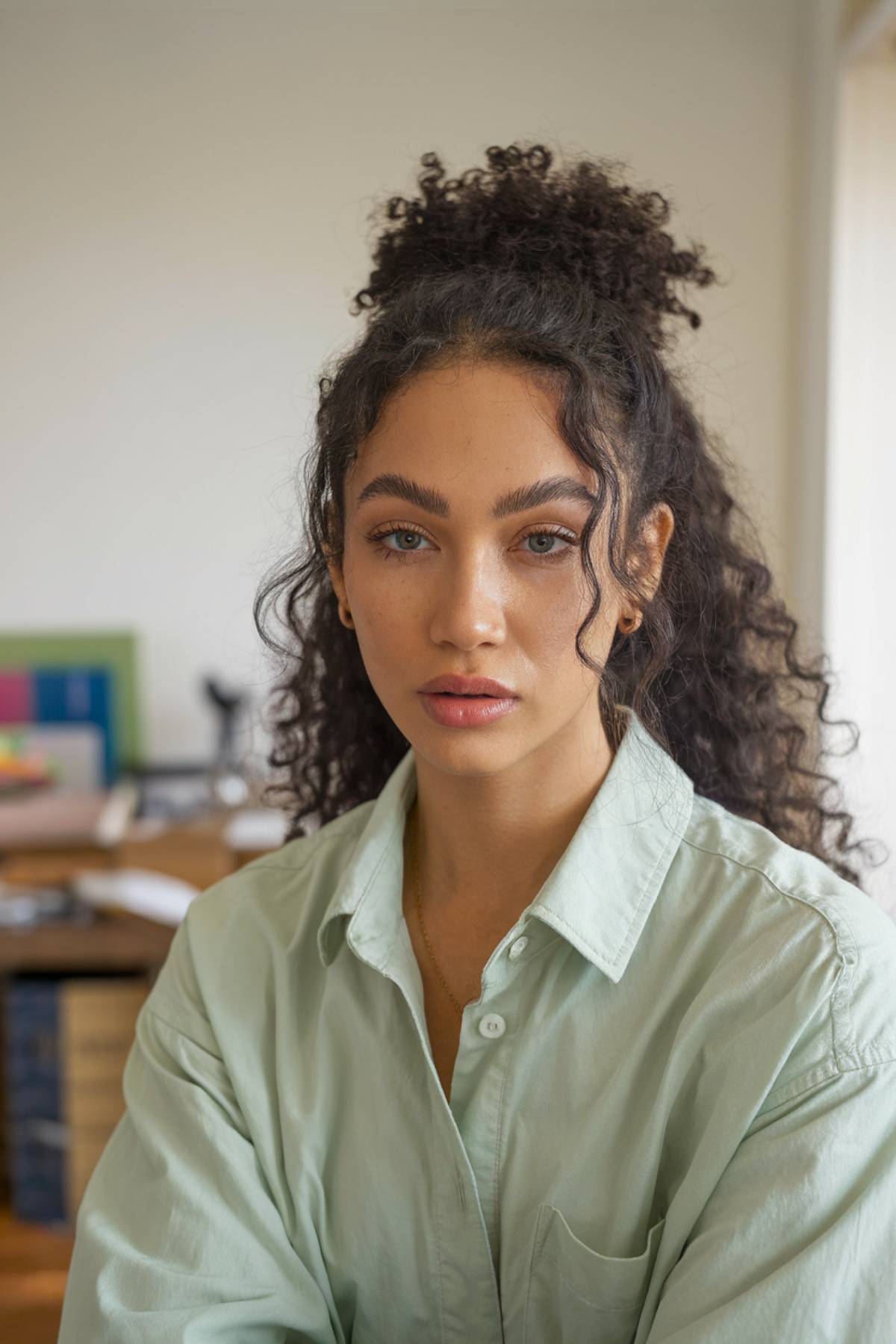 Half-up half-down curly hair bun with soft curls flowing freely