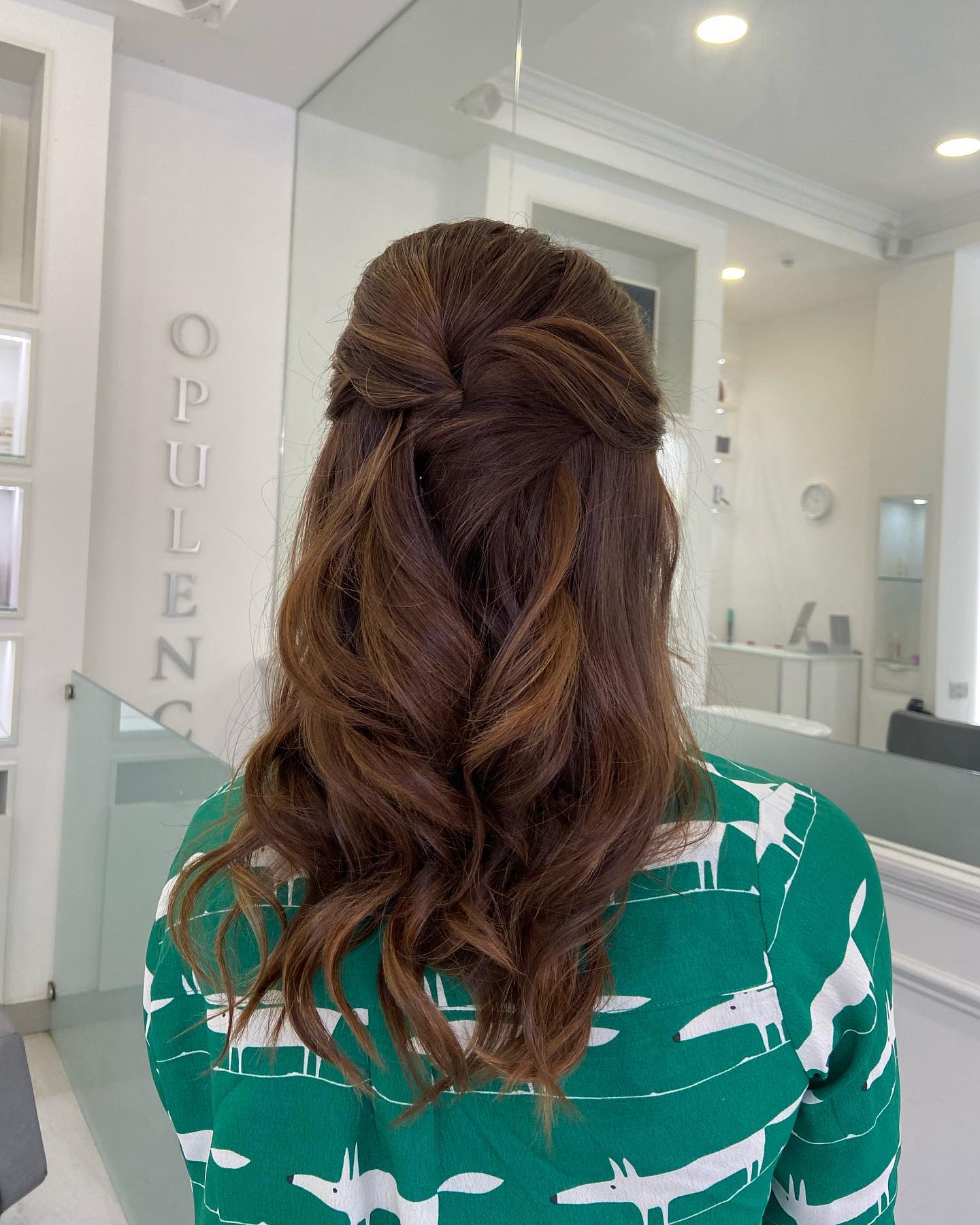 Half-up twist hairstyle with loose waves on medium to long brown hair for a soft, romantic look