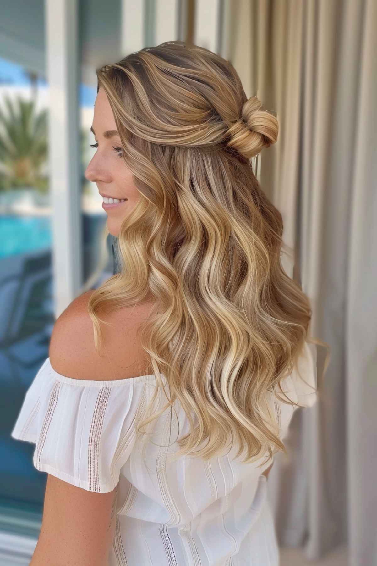 Woman with half-up wavy hairstyle and knot, perfect for summer