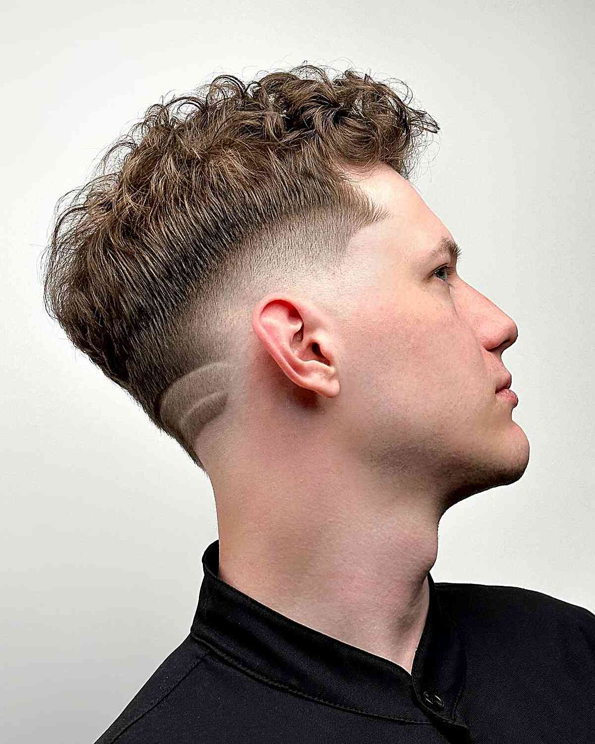 Handsome Drop Fade Cut with Designs and Textured Bangs for Guys with wavy hair