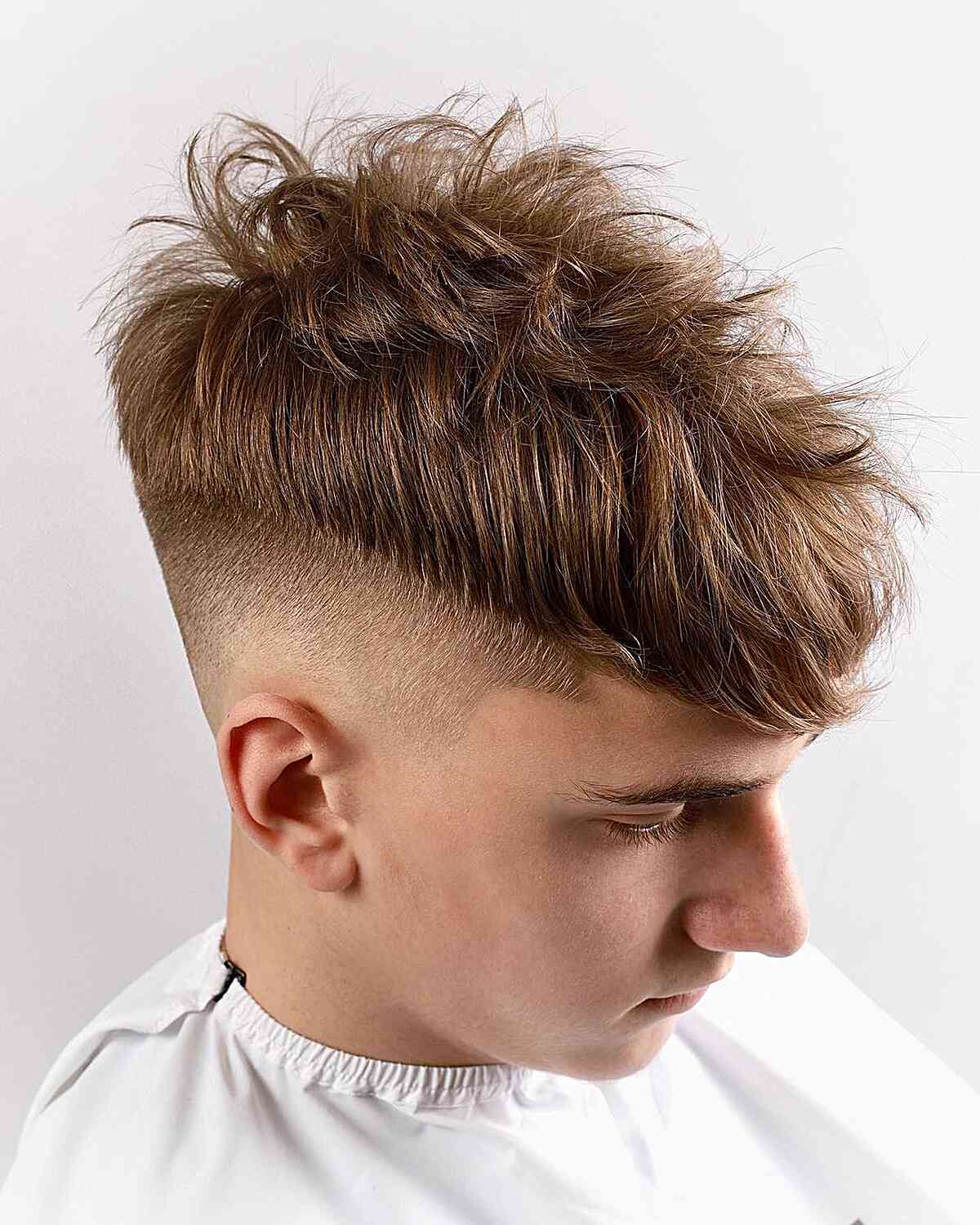 High Fade with a Messy Long Top for Teen Boys with Low Bald Fade
