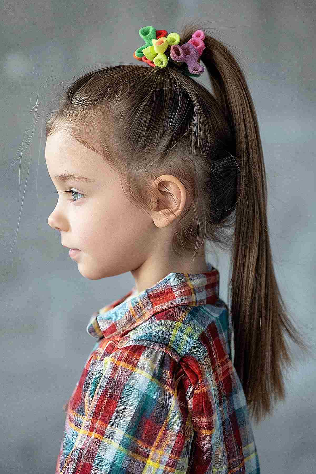 Young girl with a high ponytail and colorful scrunchies