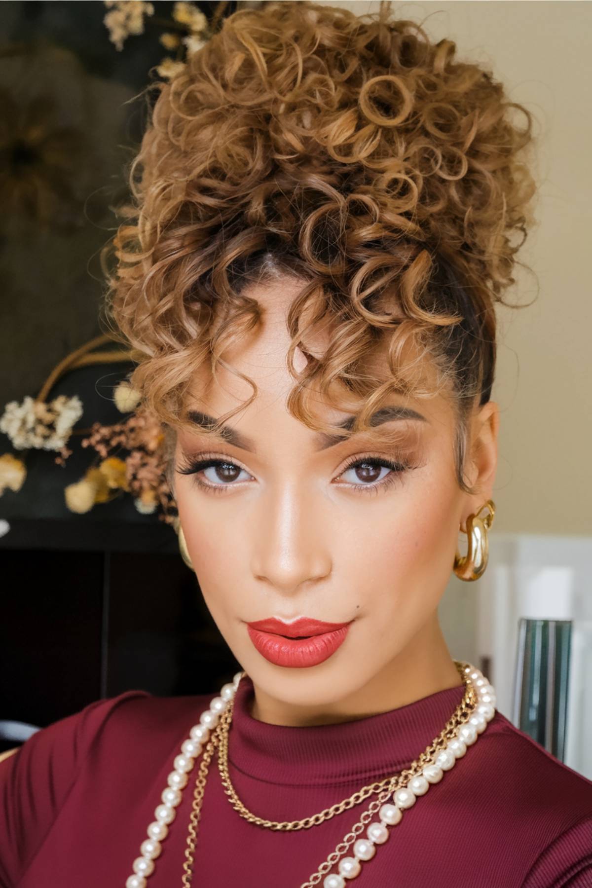 High-volume curly bun with defined ringlets, adding height and fullness