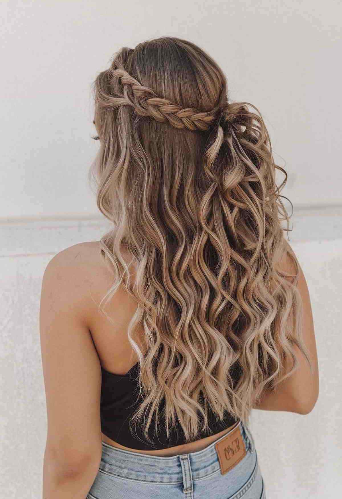 Half-up homecoming hairstyle with a chunky side braid and wavy long hair