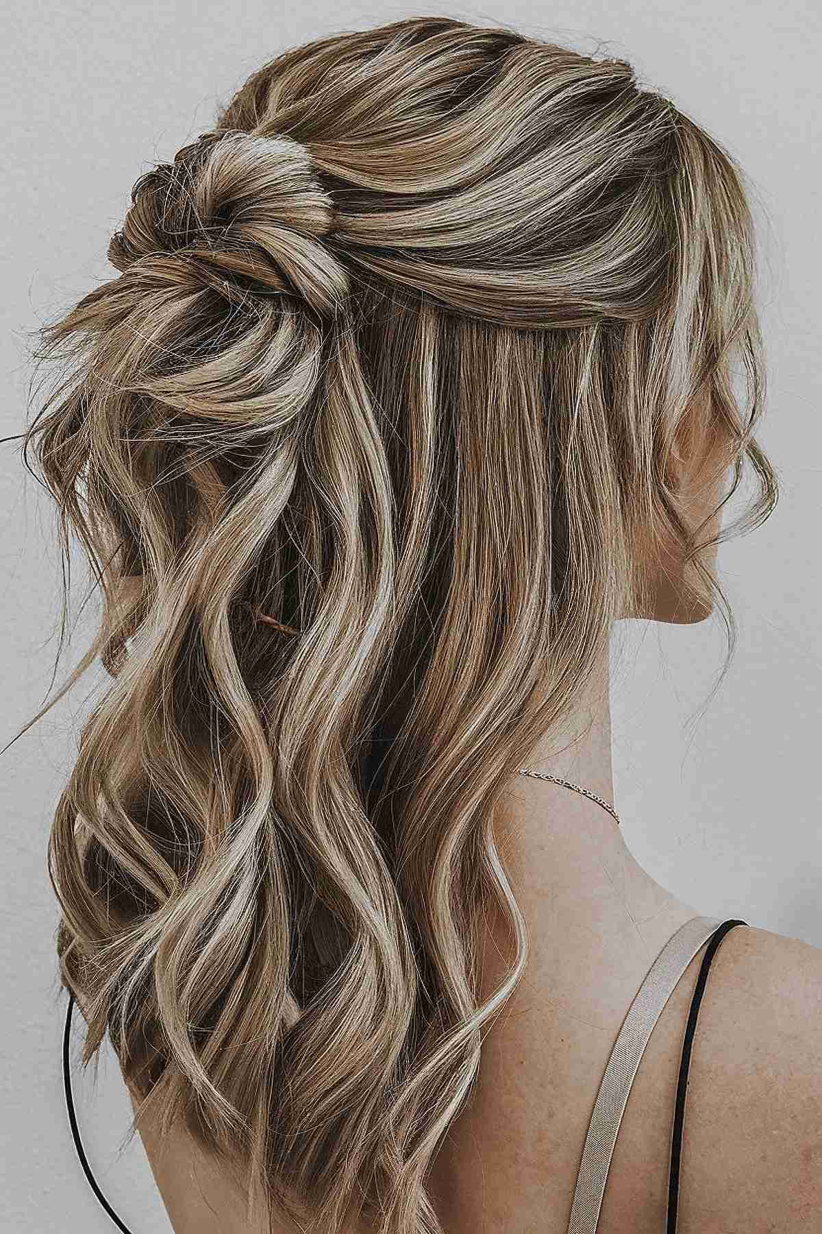 Half-up hairstyle with beachy waves and a knotted twist for medium-length hair