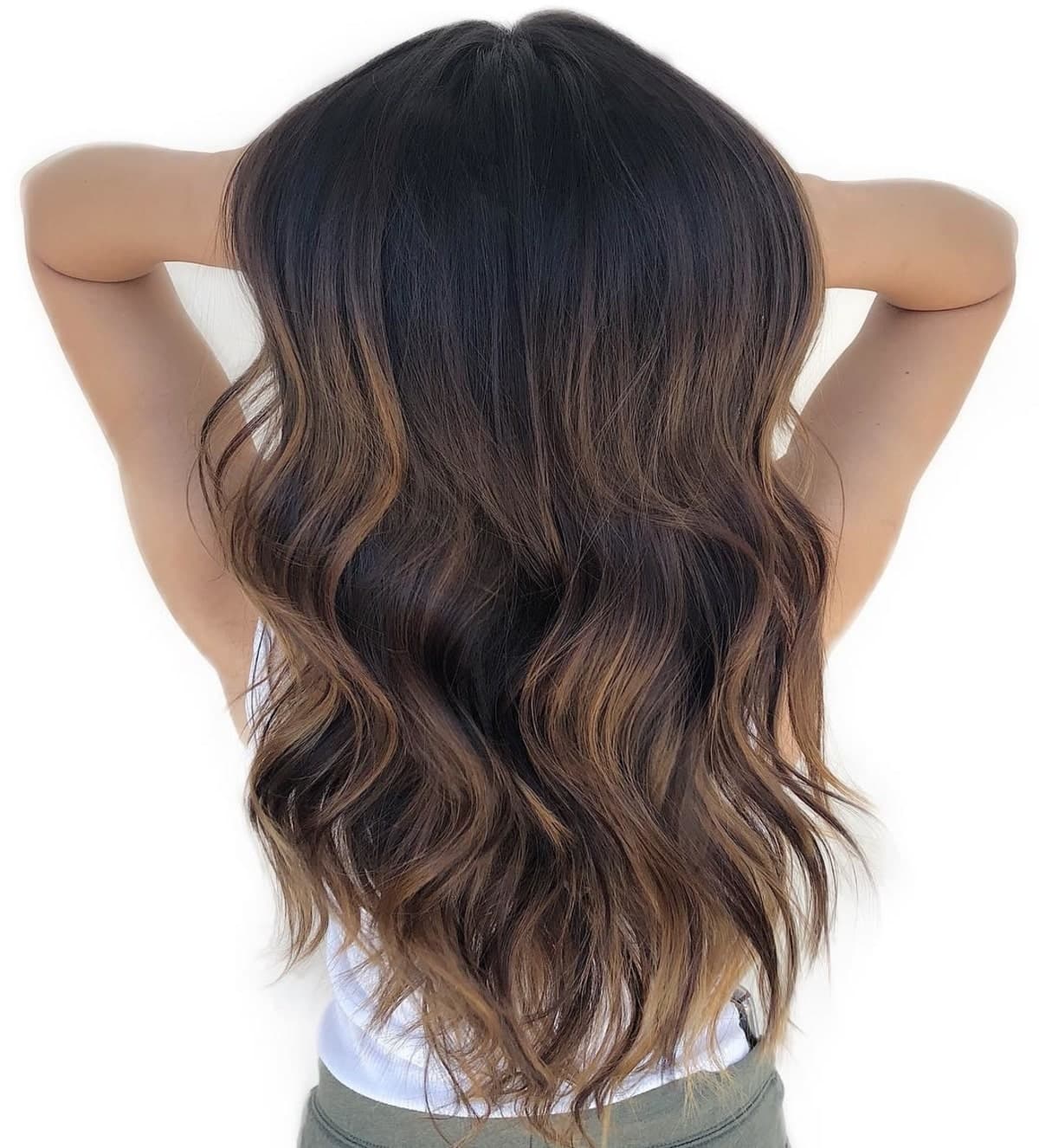 Yummy honey brown highlights on long wavy hairstyle