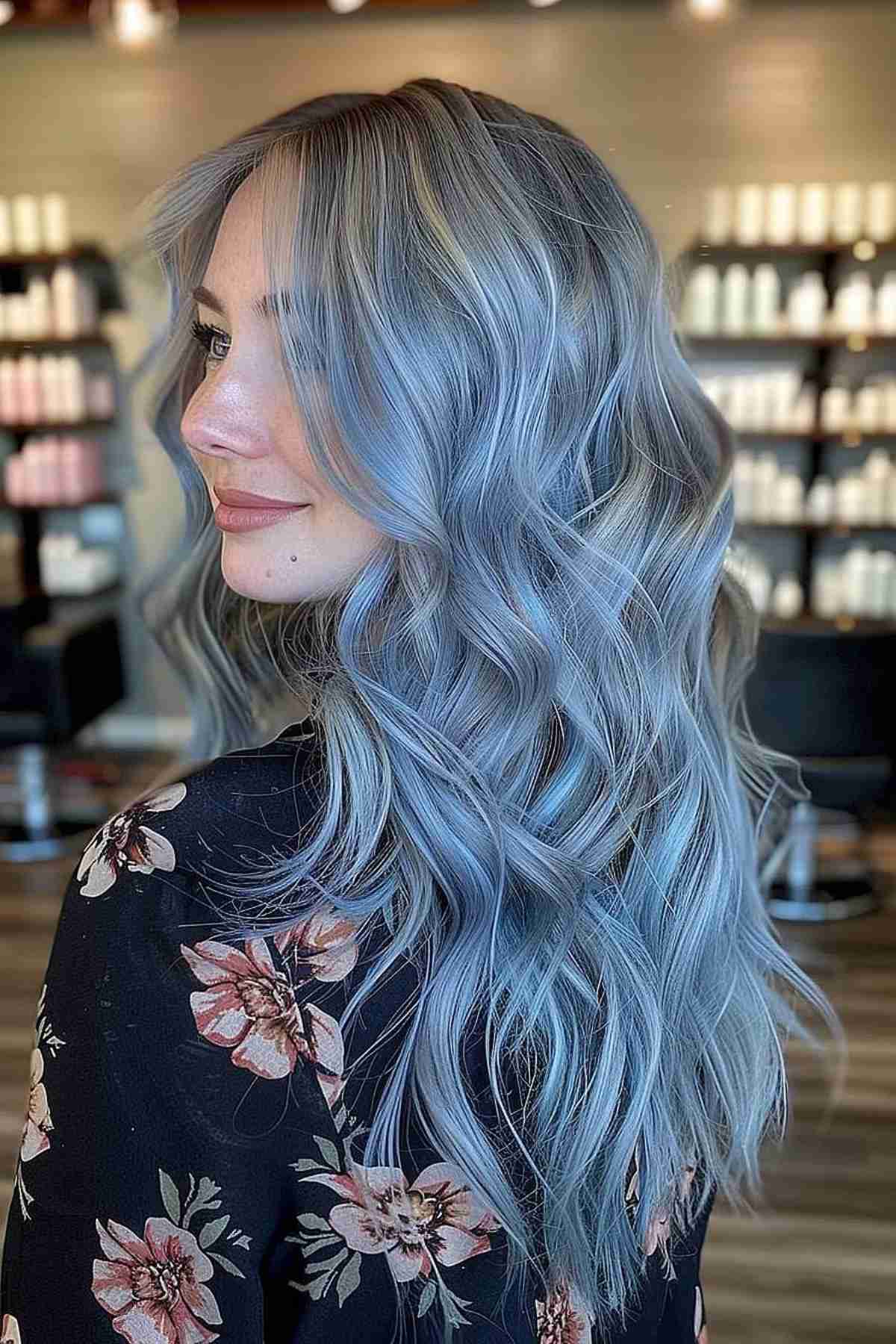 Long, wavy hair with a stunning gradient from natural silver to bold ice blue on a young woman, showcasing the trendy and edgy hair color transition