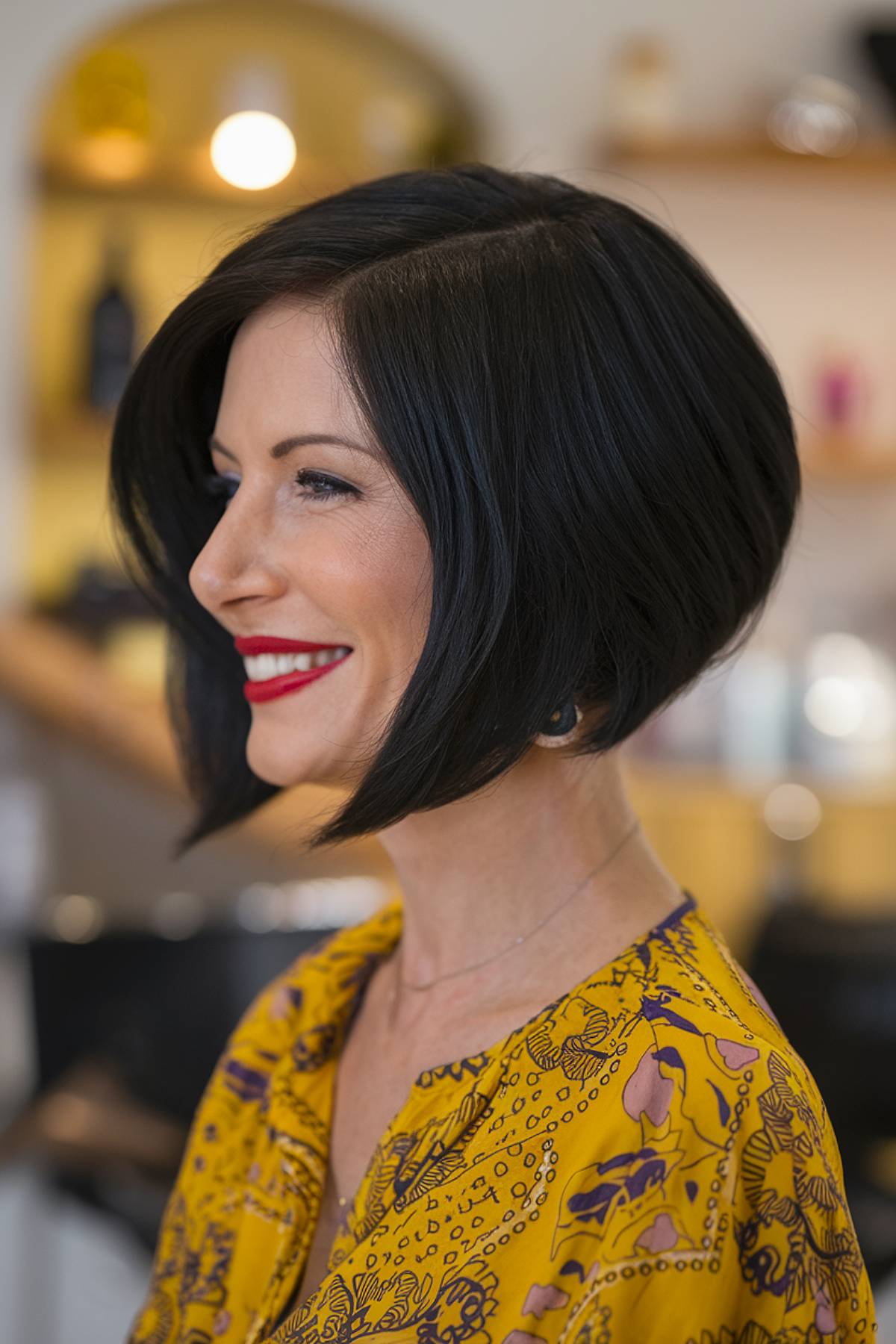 A sleek inverted angled bob with a dramatic stacked back and longer front layers, creating a bold and polished look