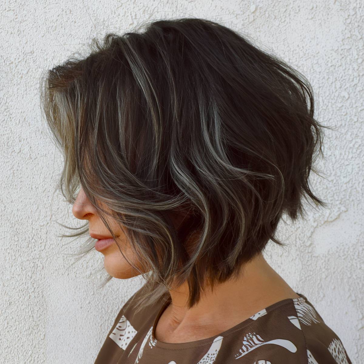 Inverted bob with stacked layers at the back, creating volume and movement, ideal for older women with fine hair