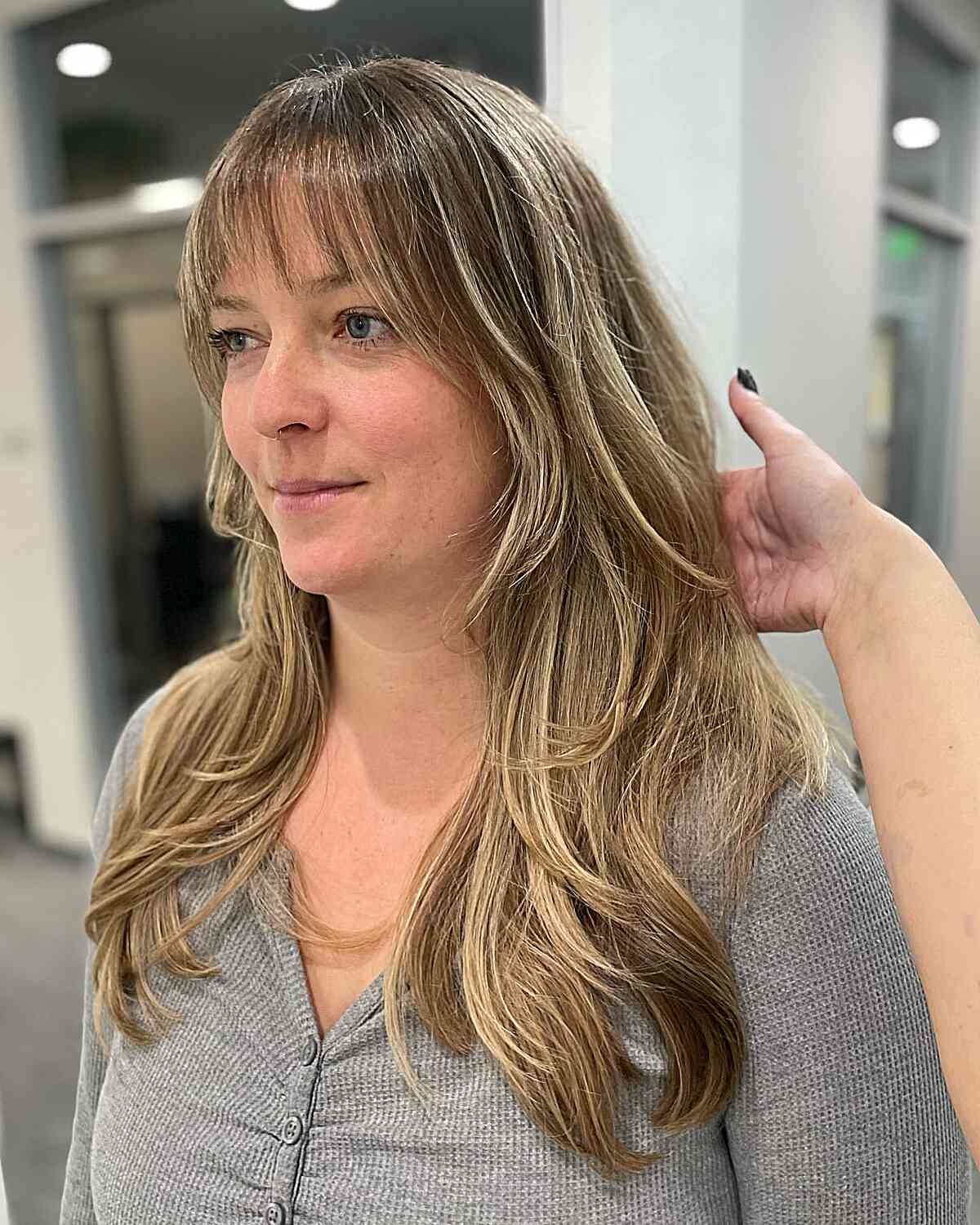 Chest-Length Layered Blonde Balayage Highlights and Wispy Bangs