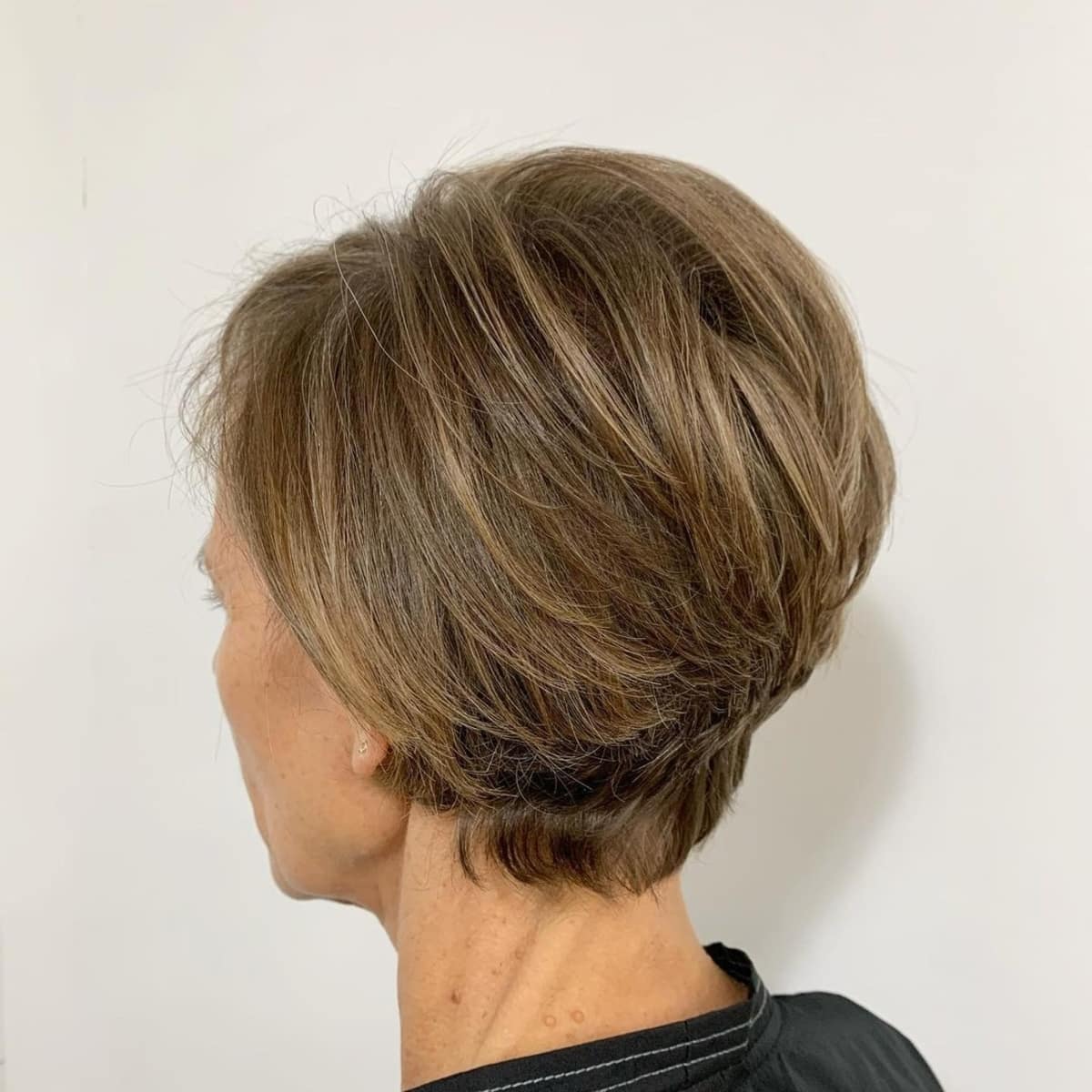 Light brown pixie with subtle highlights for older women