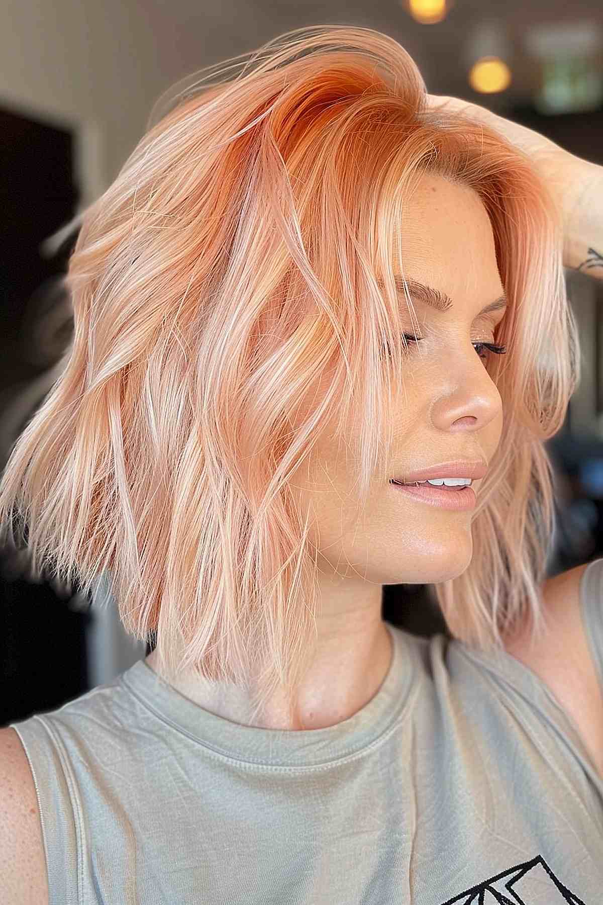 Stylish light peach layered bob that enhances volume and texture, perfectly framing the face while offering a chic, easy-to-manage hairstyle.