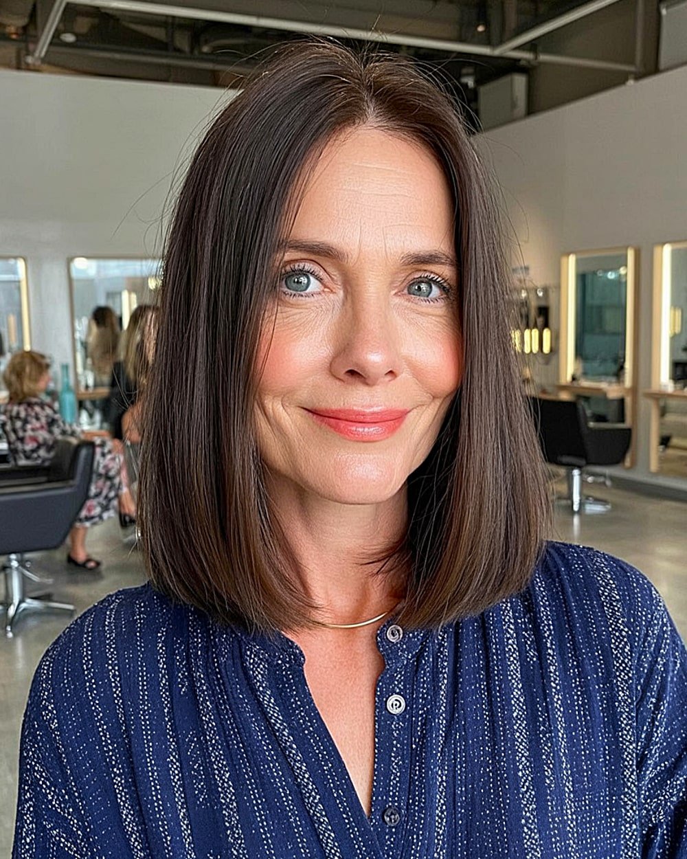 Blunt cut long bob with middle part for mature women over 50 with straight thick hair
