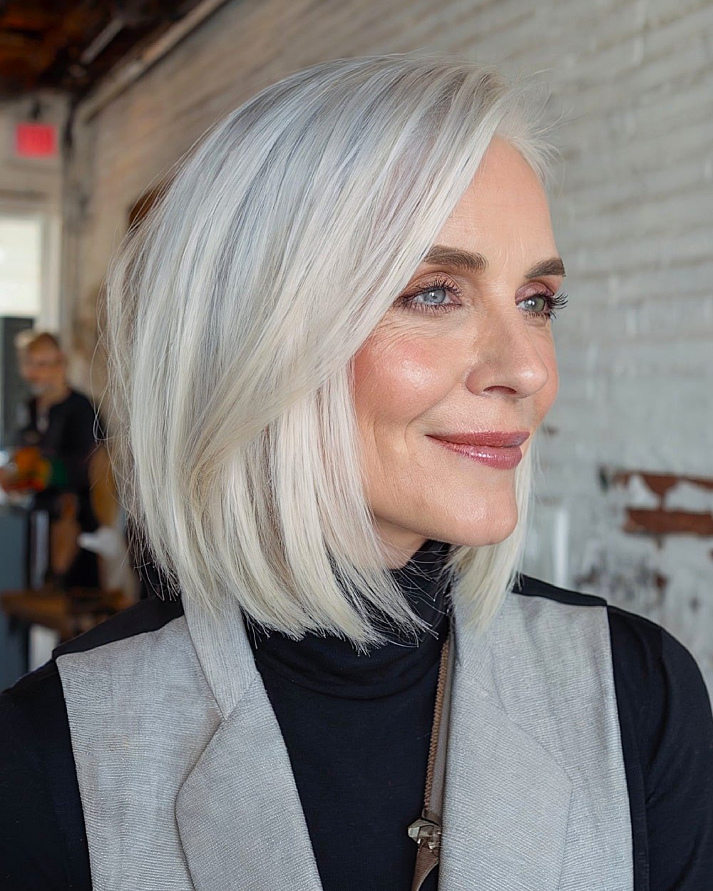 Sleek long bob with deep side part for women over 50 with thick straight or smooth hair