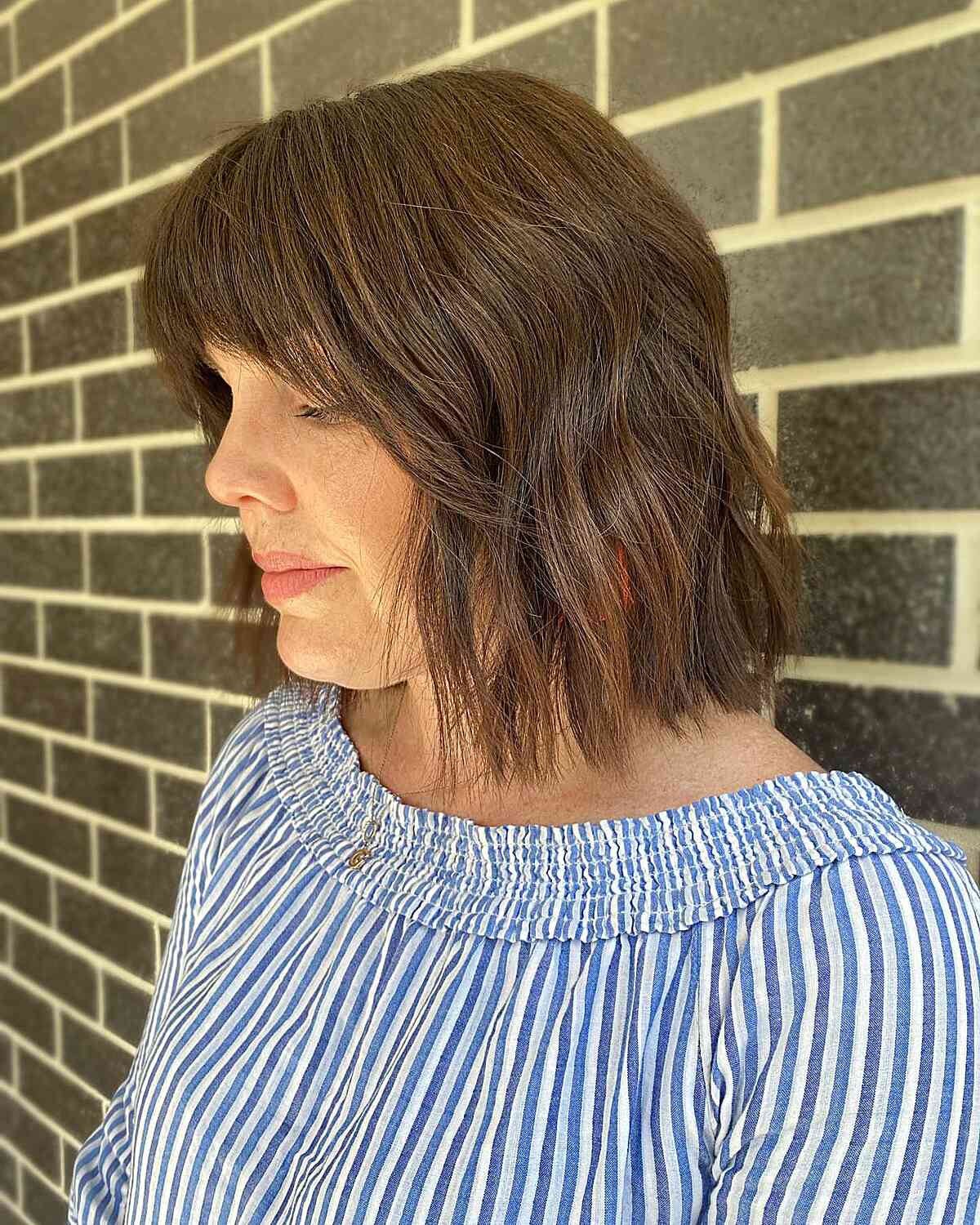 Long Brunette Bobbed Hair with Subtle Choppy Layers and Bottleneck Bangs