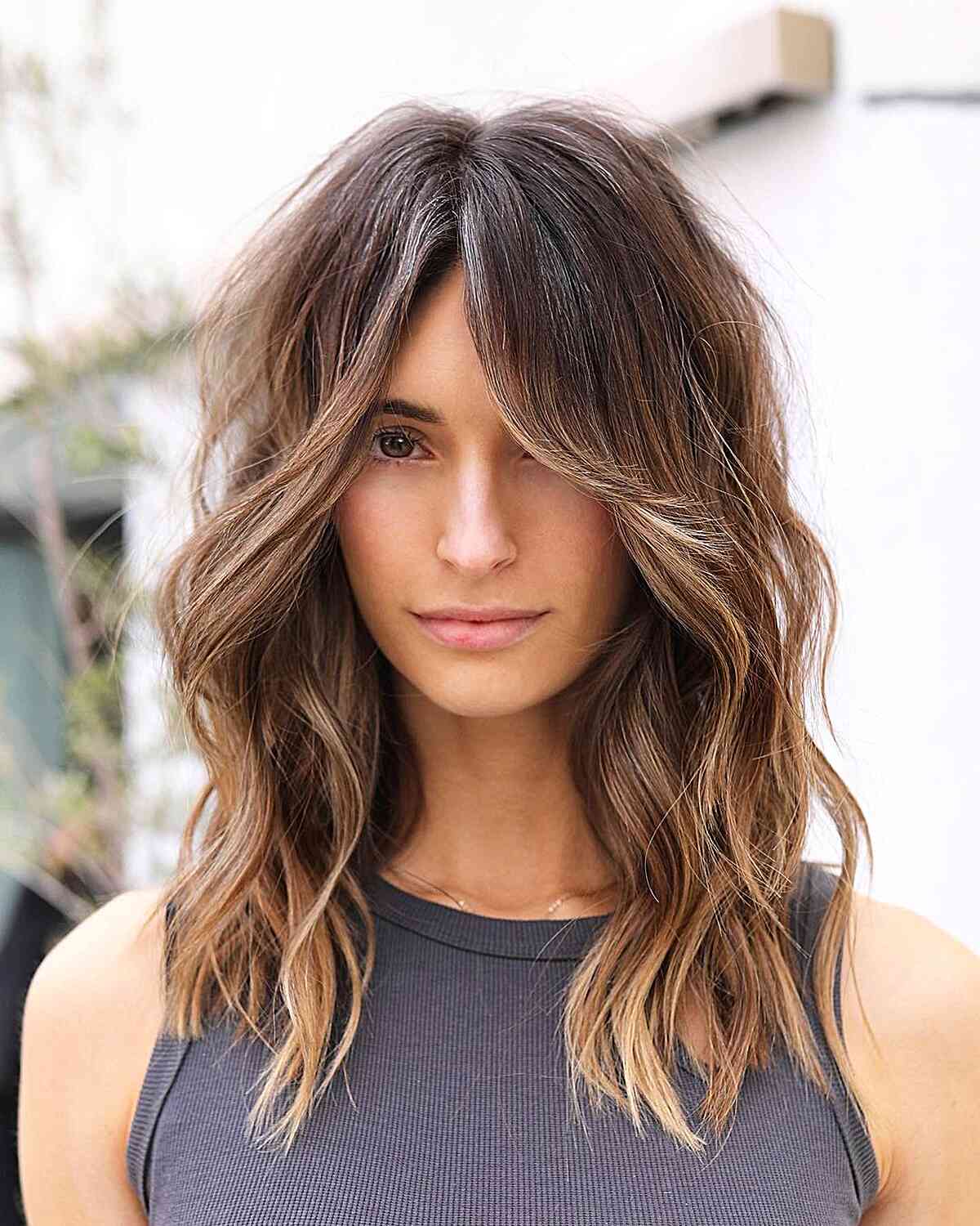 Long Curtain Bangs on a Mid-Length Chop with brown balayage and waves