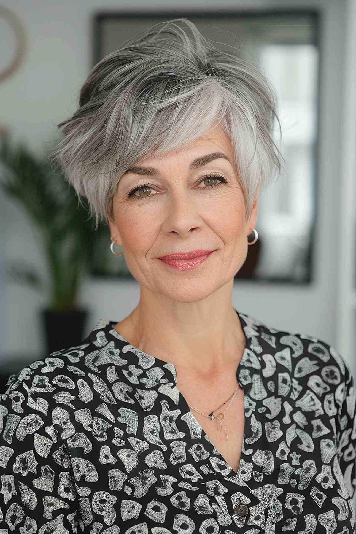 Woman with a grey hair pixie cut, side-swept bangs, and layers