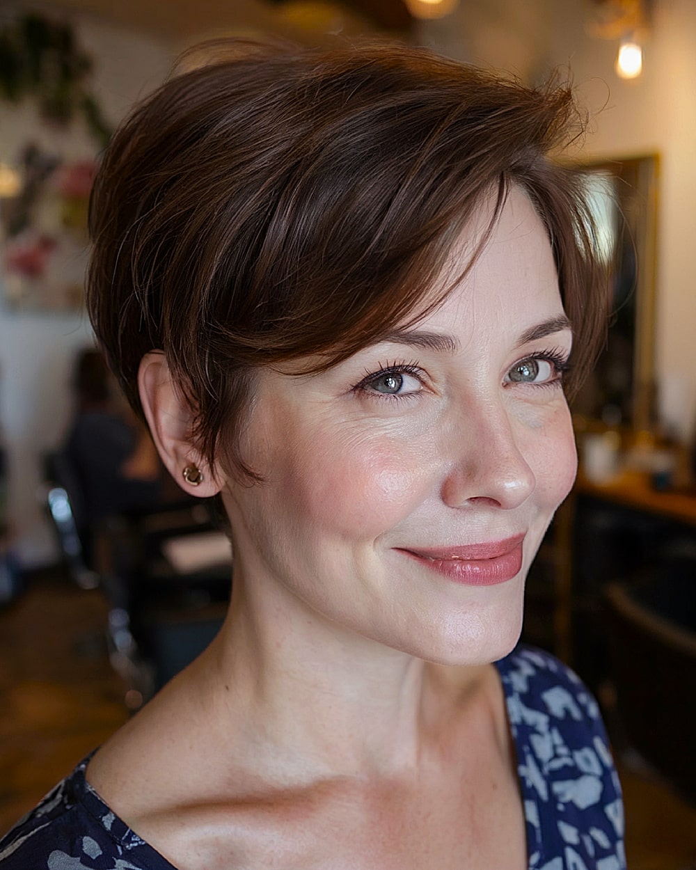 Long pixie haircut for women over 40 with side-swept bangs and soft brunette layers