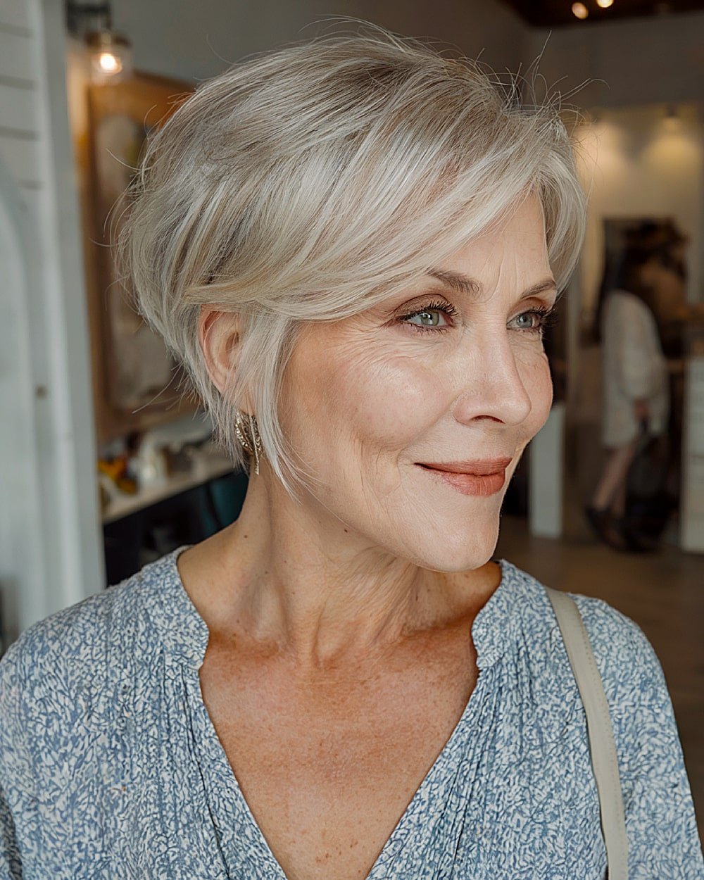 Long pixie with side part and soft feathered layers for women over 60