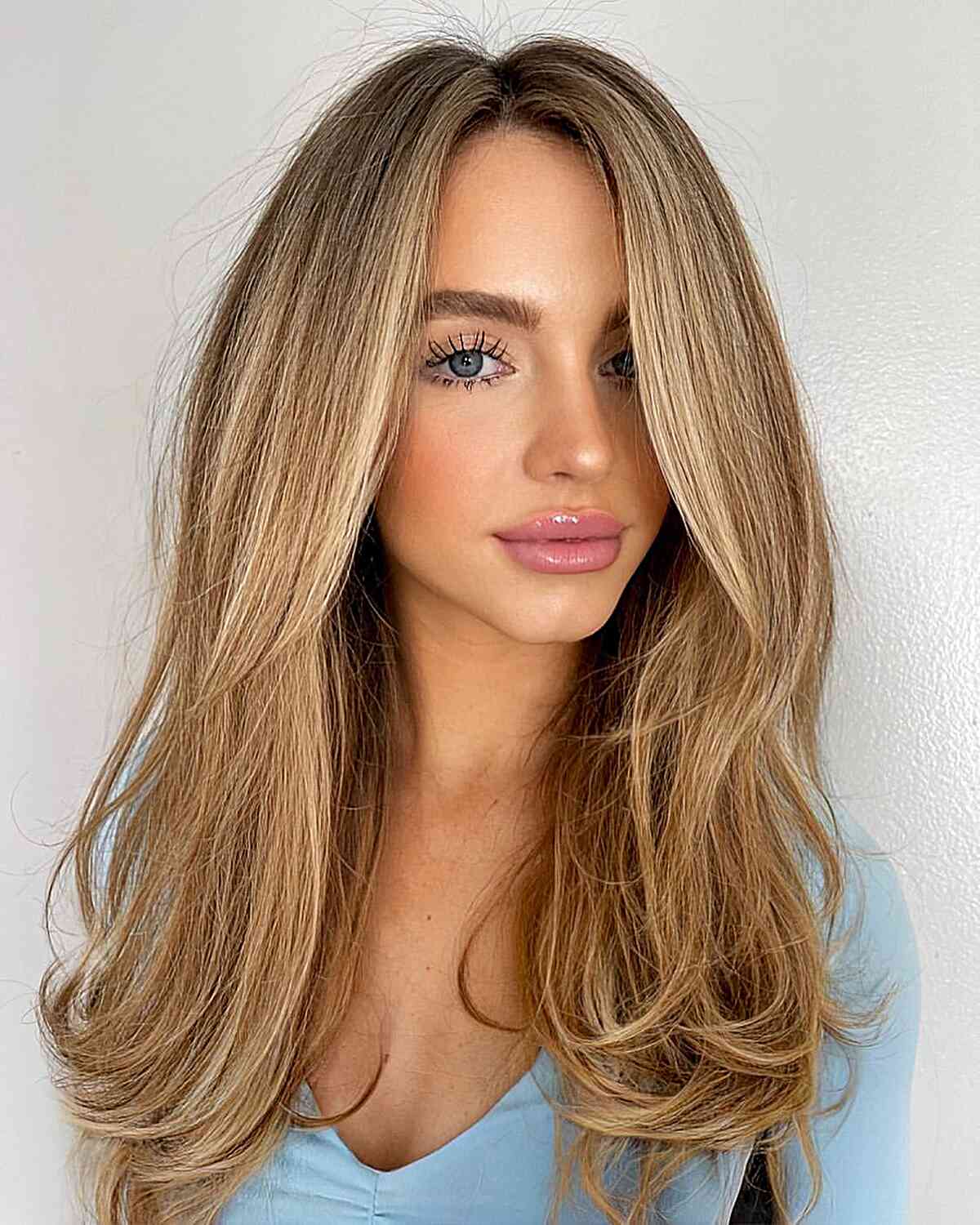 Long Straight Hair with Face-Framing Layers and Balayage with a Subtle Side Part