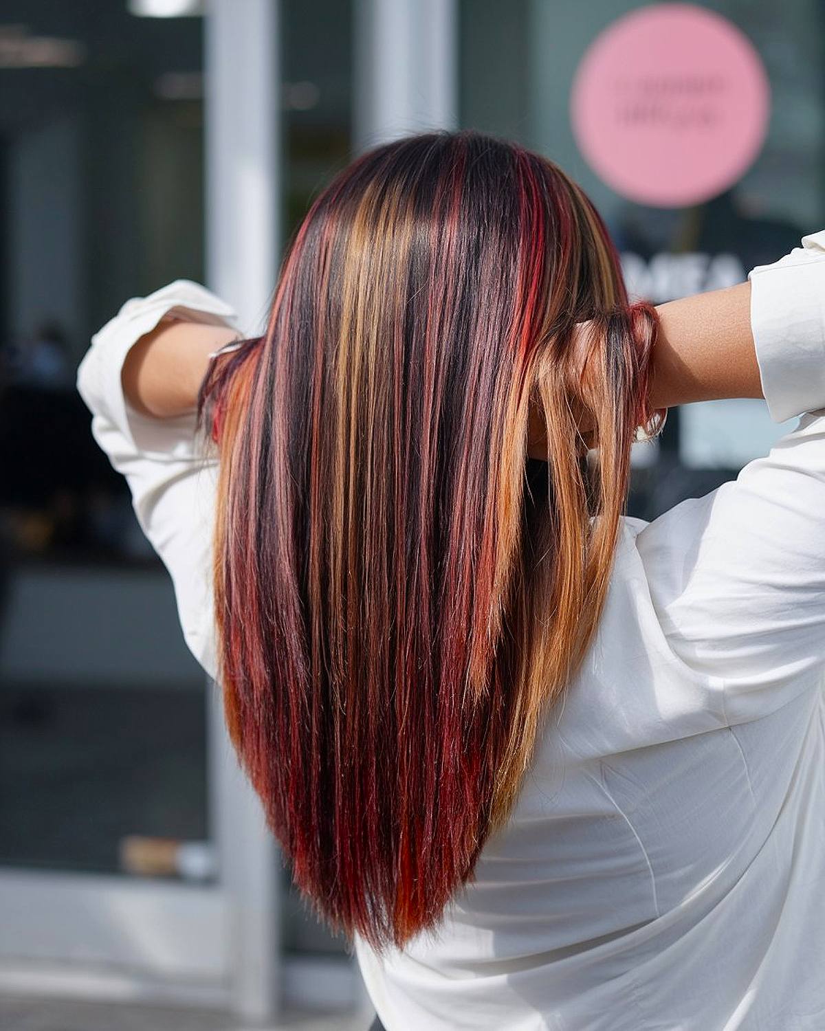 Long V-cut layers with bold red and blonde highlights