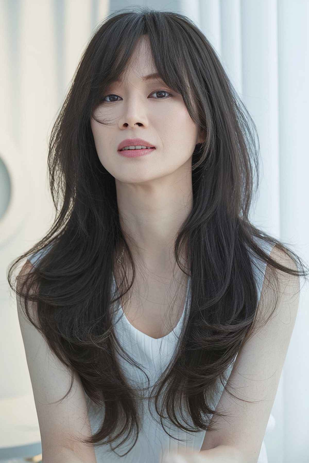 Long wavy hair with curtain bangs, ideal for asian women over 40 