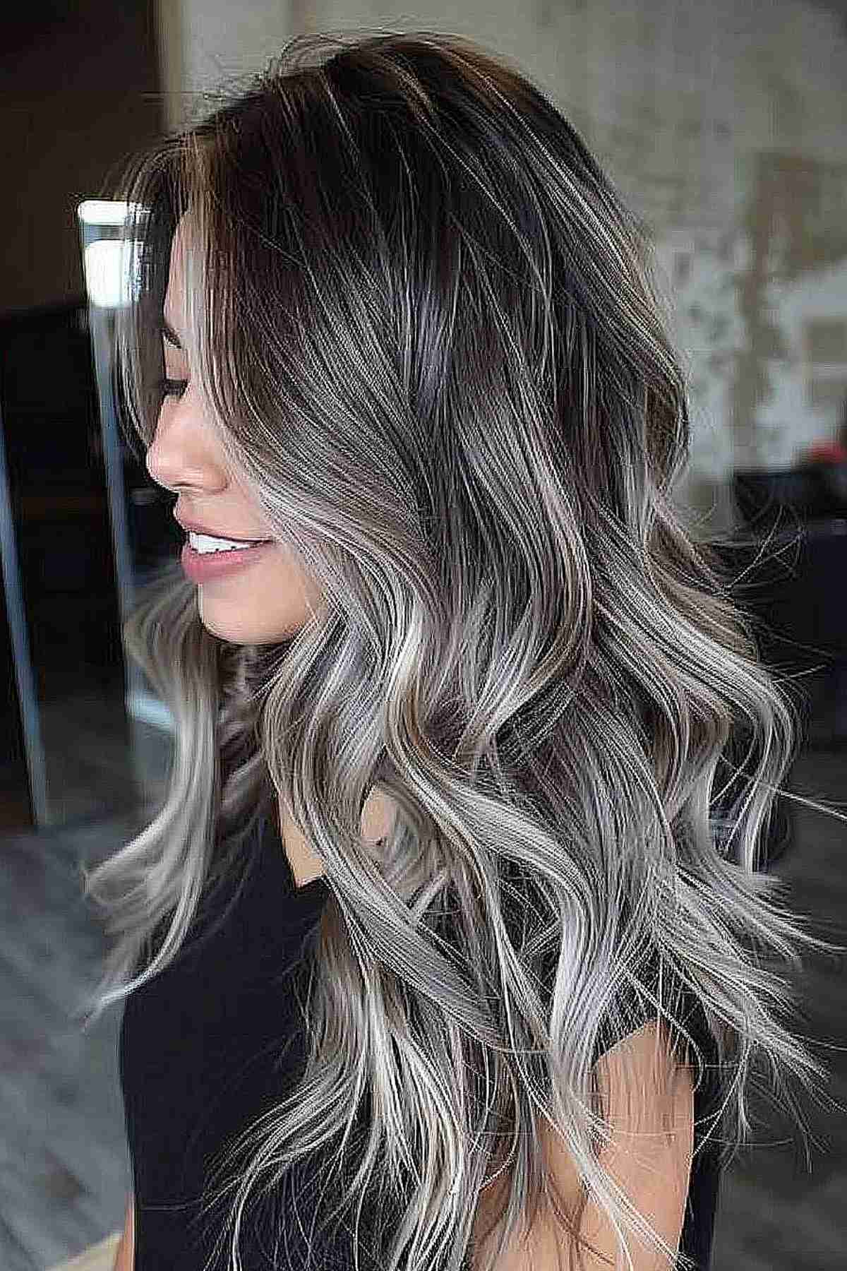 Long wavy hairstyle with a silver metallic gradient perfect for adding volume to dense hair