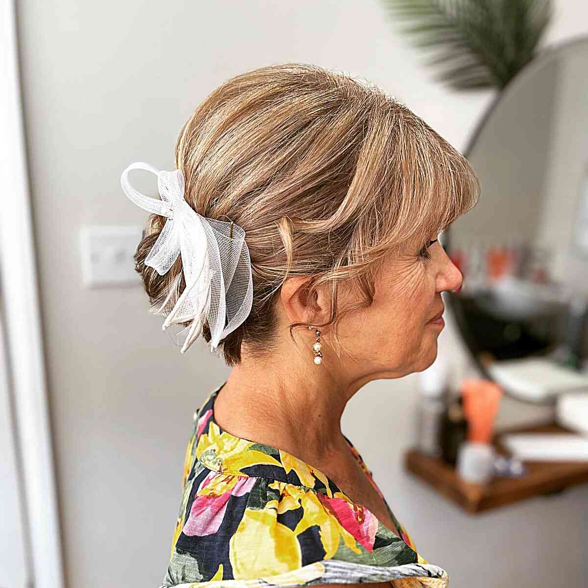 Low Bun with Ribbon and Bangs for the Grooms Mom