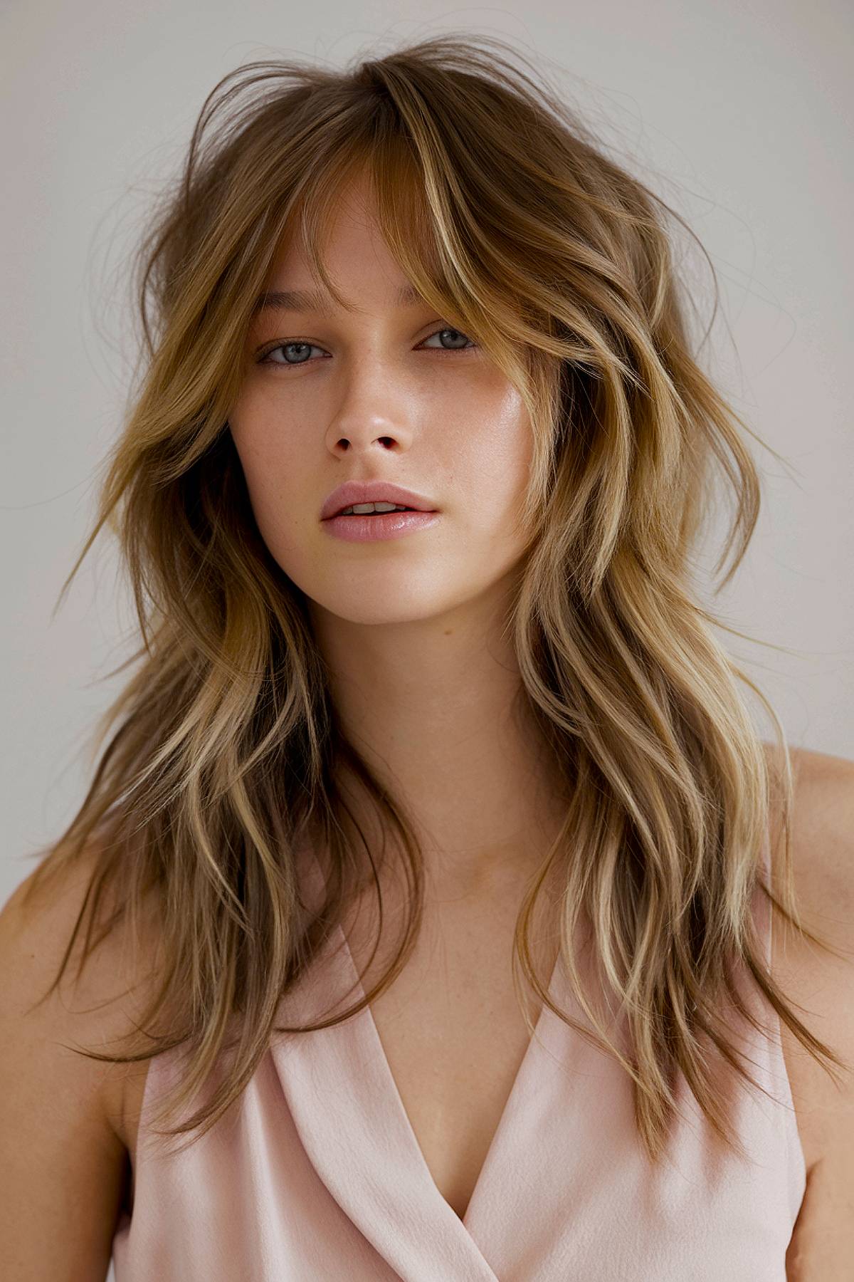 Lushlight shag haircut with layered waves and curtain bangs, enhancing movement in fine hair