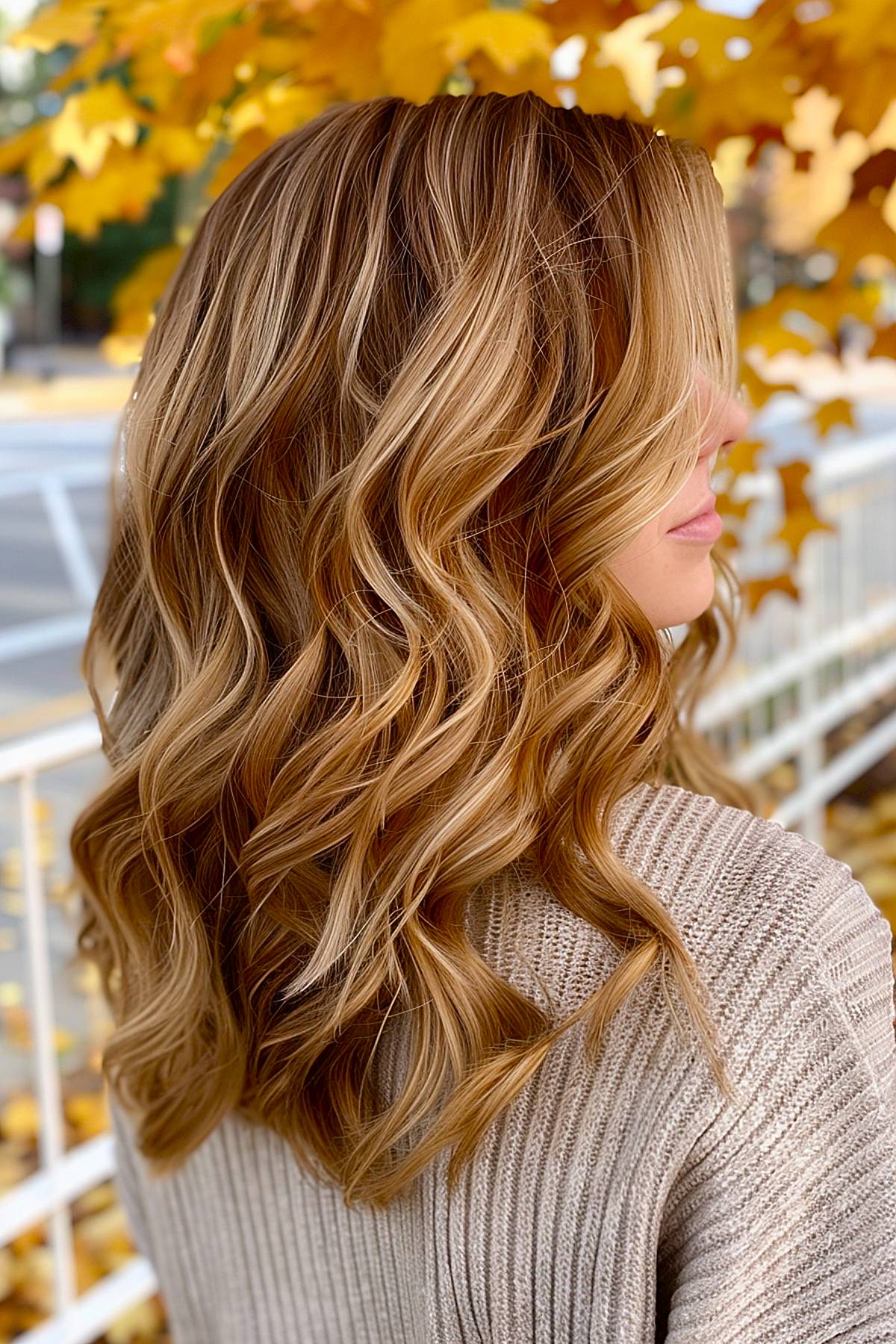 Mapleglow hair color with honey and maple highlights on light brown wavy hair