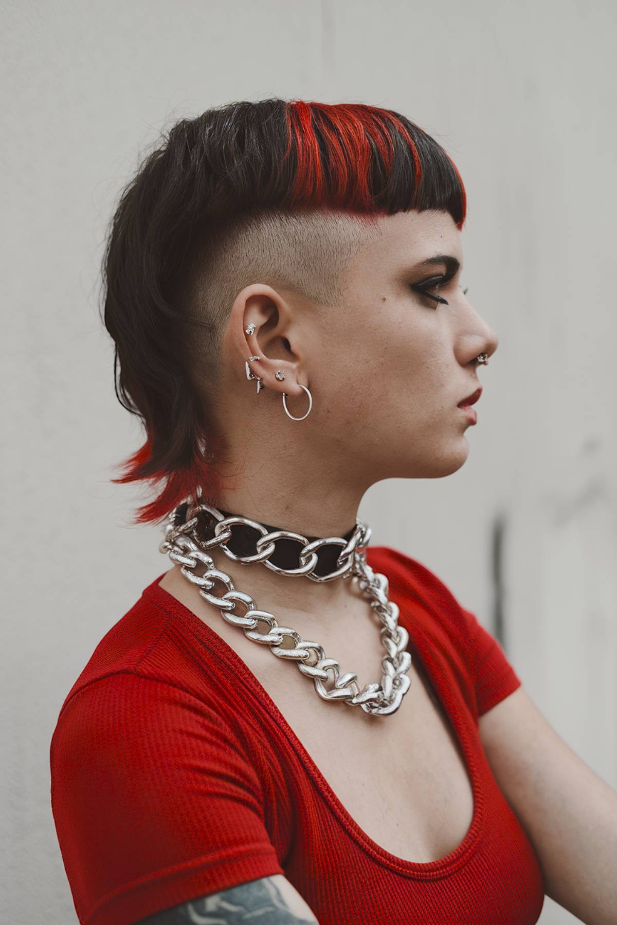 Masculine mullet with sharp undercut and bold red highlights for an edgy, punk-inspired style