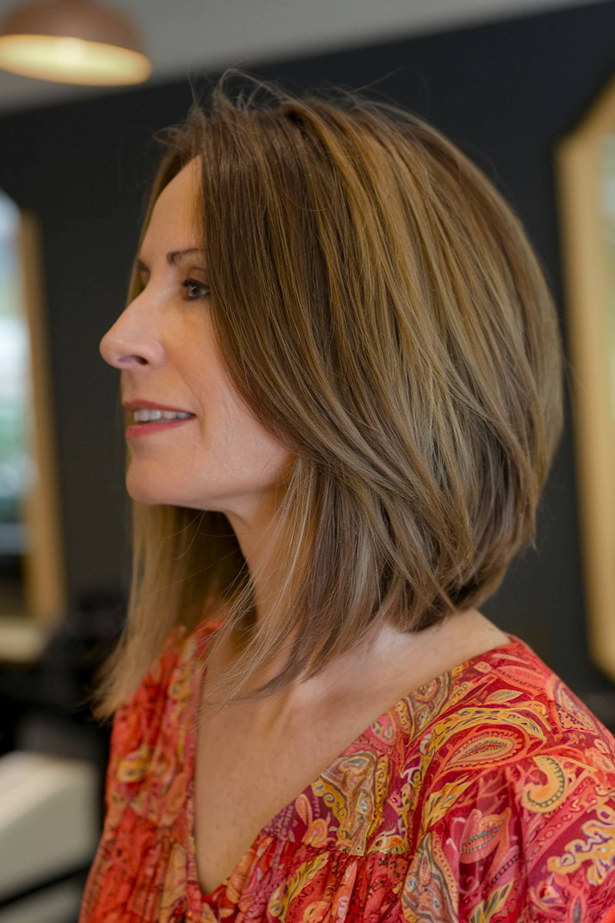 A soft, layered medium-length angled bob that adds movement and texture, perfect for women over 40 with thick or wavy hair