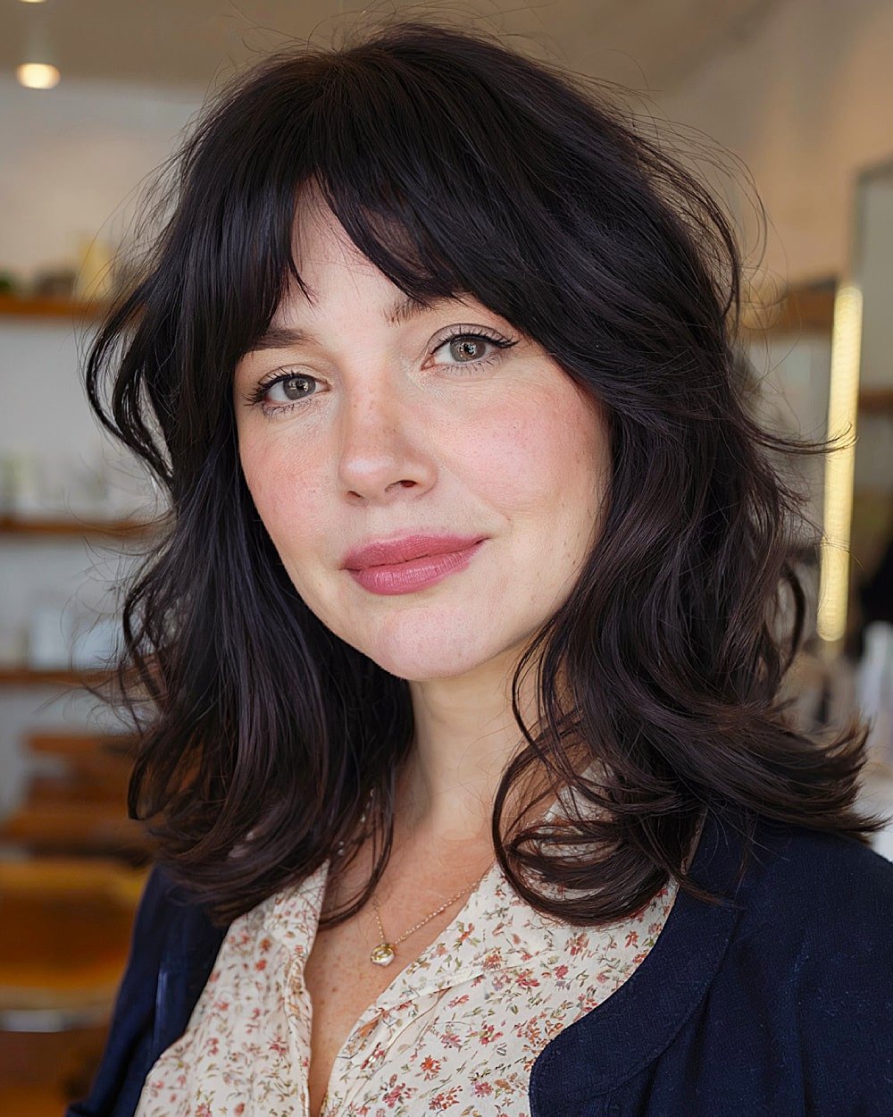 Medium-length haircut with layered curtain bangs for round-faced women over 40