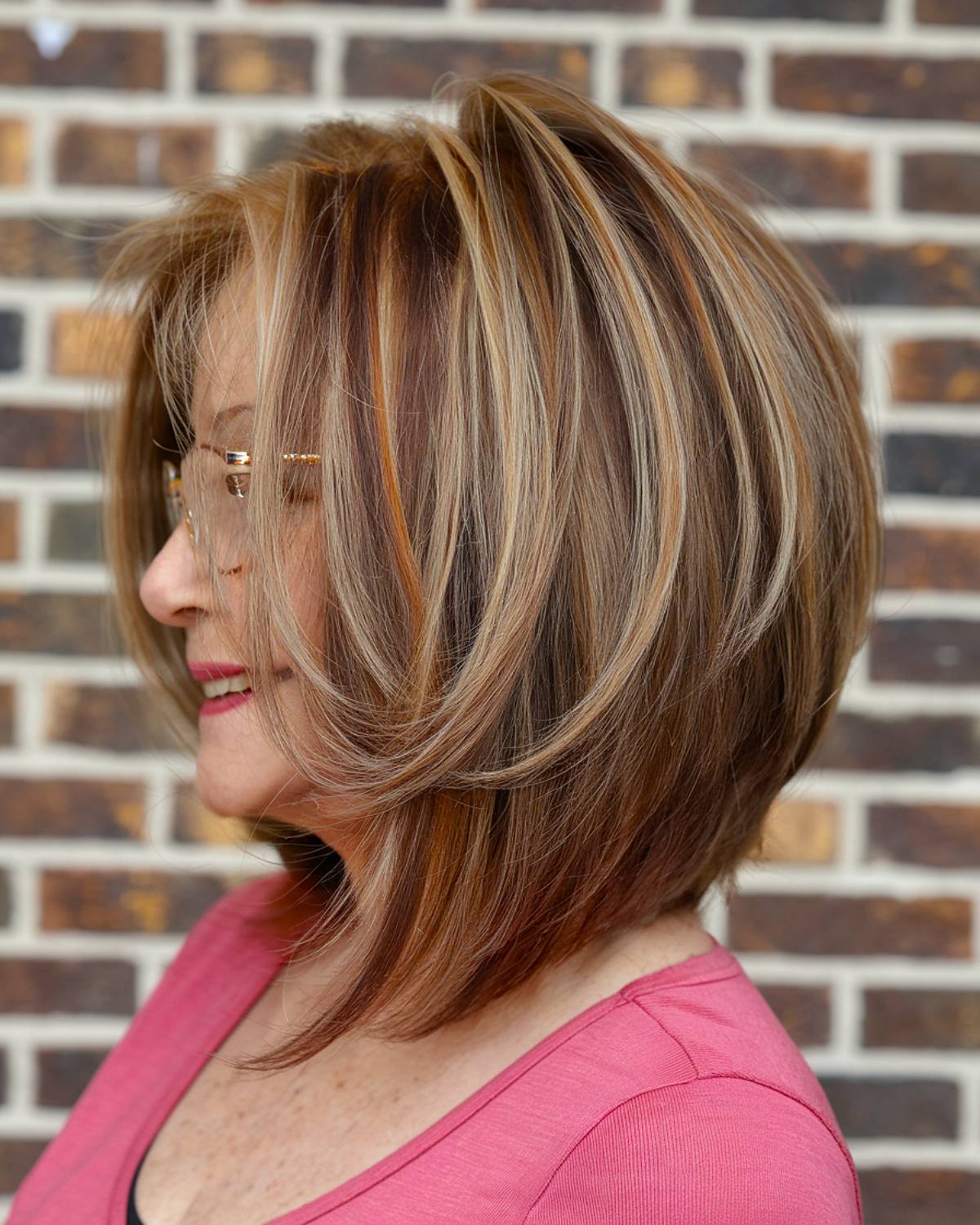 A modern medium-length angled bob with layered highlights, adding depth and dimension for senior women