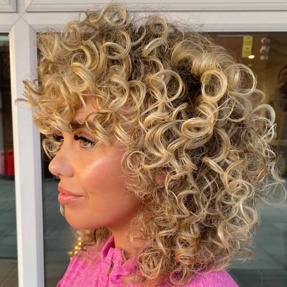 Medium-length curly hair with light bangs