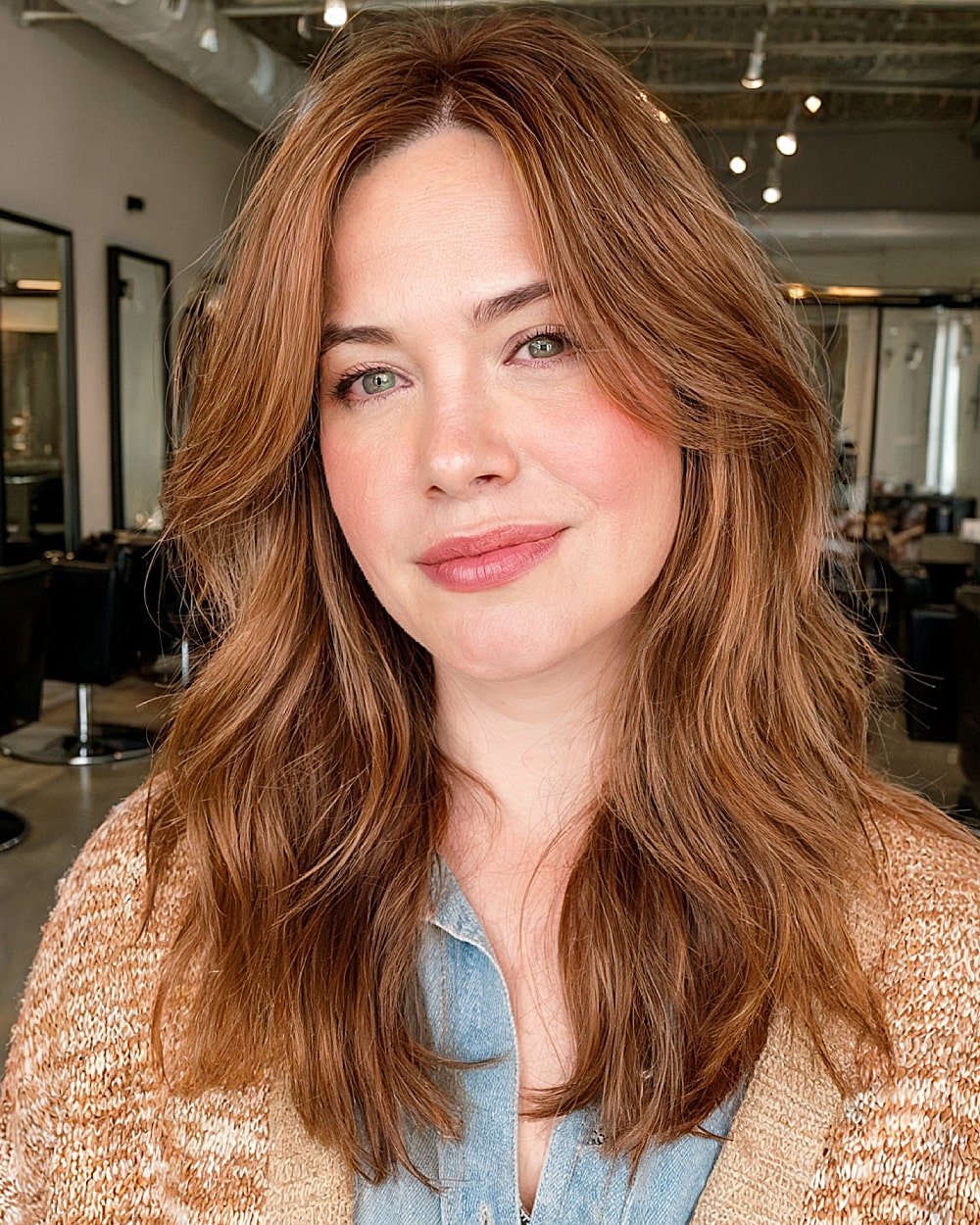 Medium copper brown haircut with soft face-framing layers and wispy ends for round faces over 40