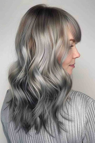 A Medium-length silver to dark grey reverse ombre with waves for a voluminous look