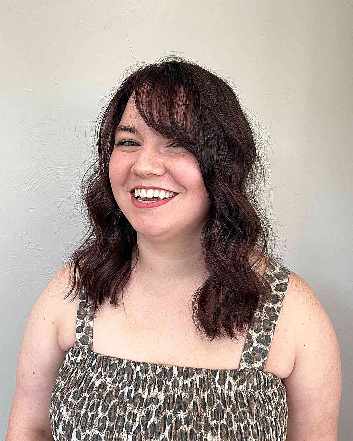 Medium-Length Soft Waves and a Wispy Side Fringe for Women with Round Faces