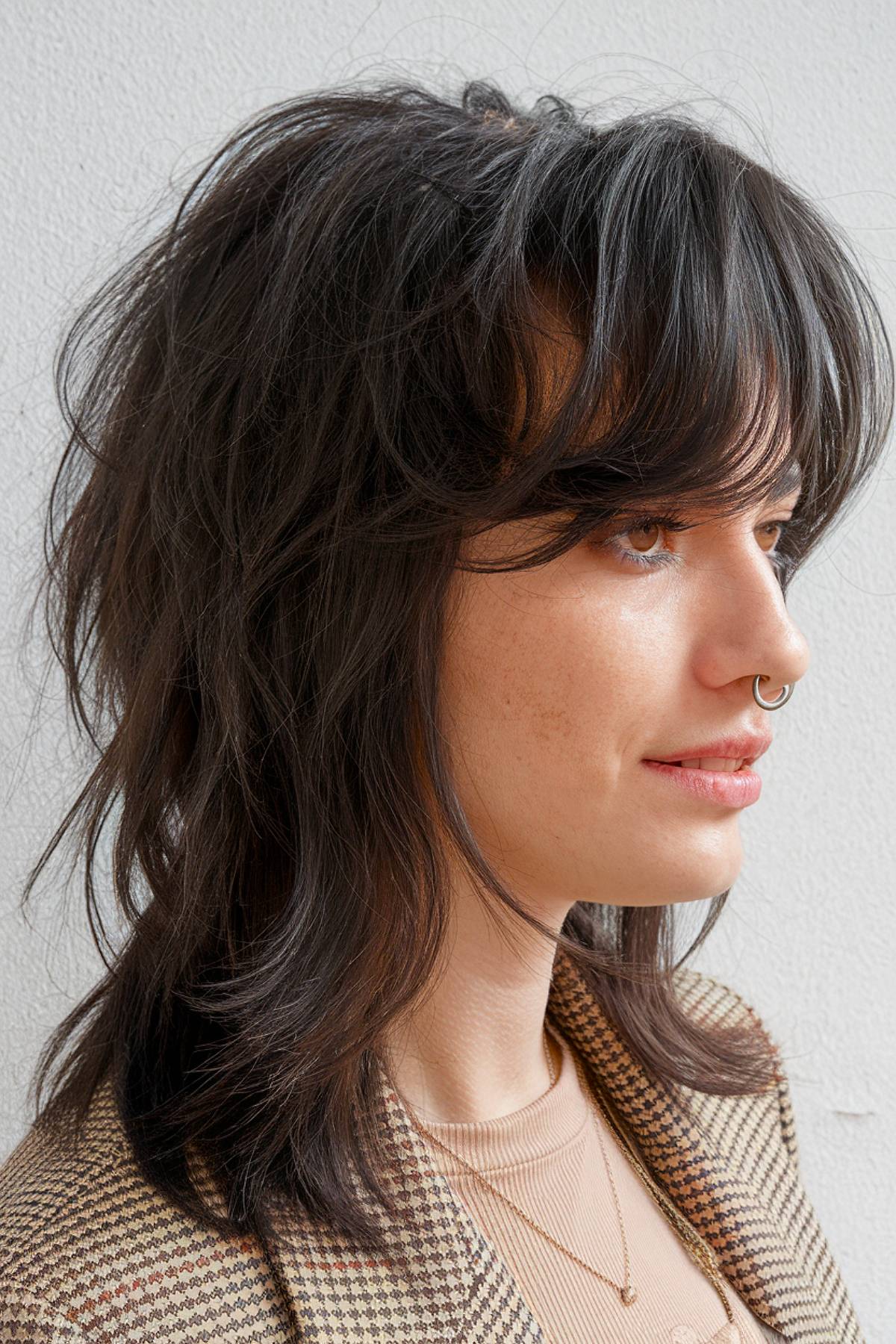 Medium mullet with wispy layers and soft feathered bangs for a relaxed, natural look