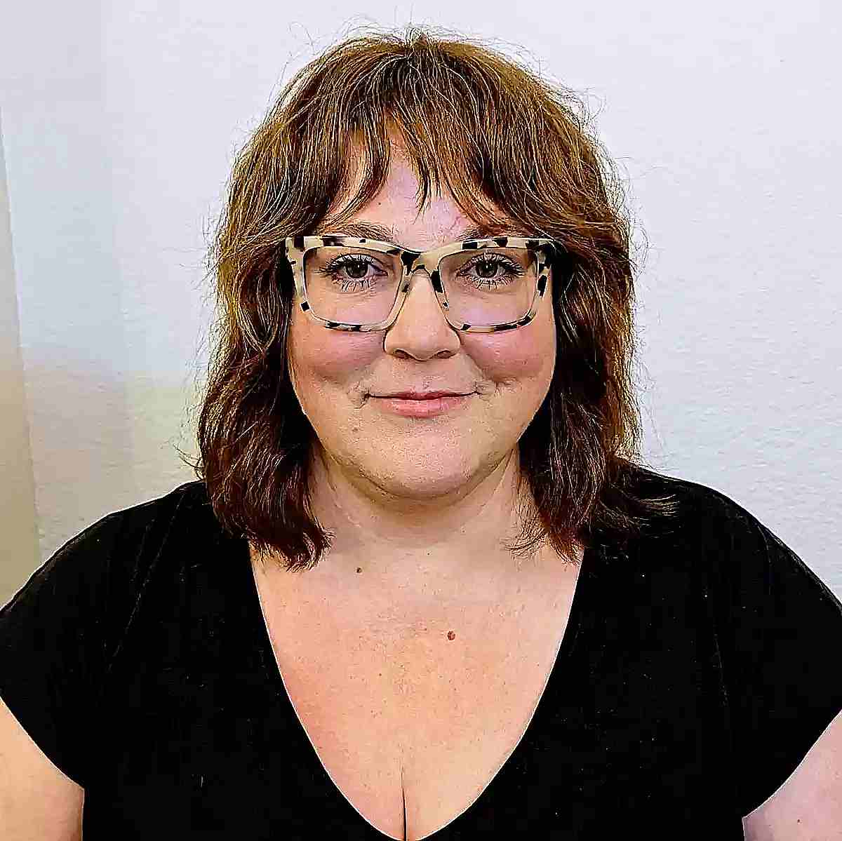 Medium Shaggy Haircut with Thin Bangs for Ladies Aged 40 with Glasses