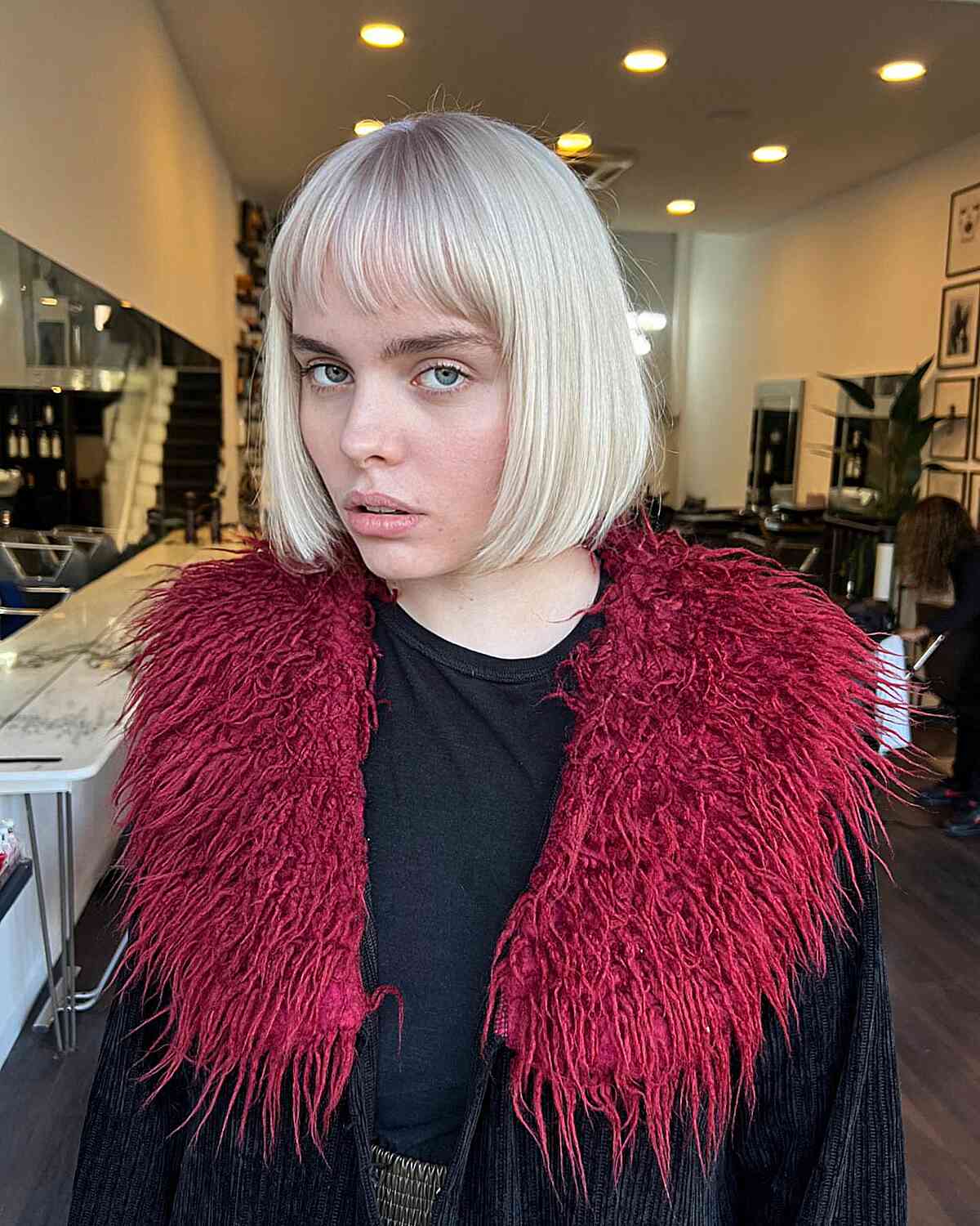 Medium to Short Bob with Subtle Layers and Bangs for Oval Face Shapes with White-Blonde Color