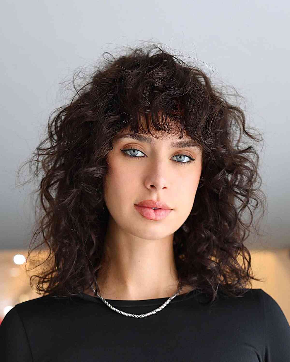 Messy and Frizzy Curly Cut with Fringe for women with shoulder-length hair