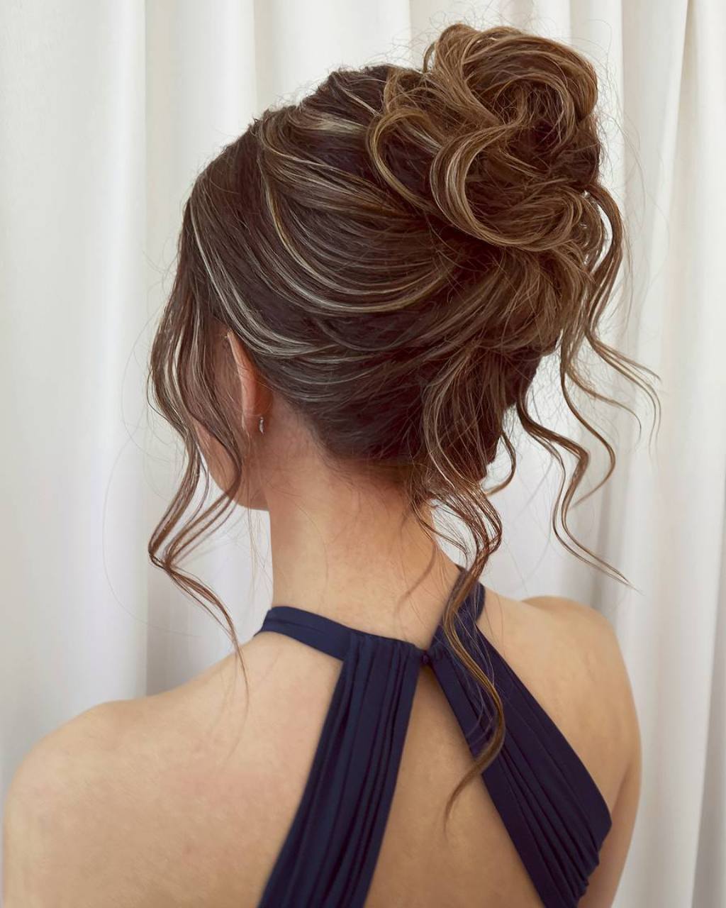 Textured messy prom updo with loose tendrils for a soft, romantic finish